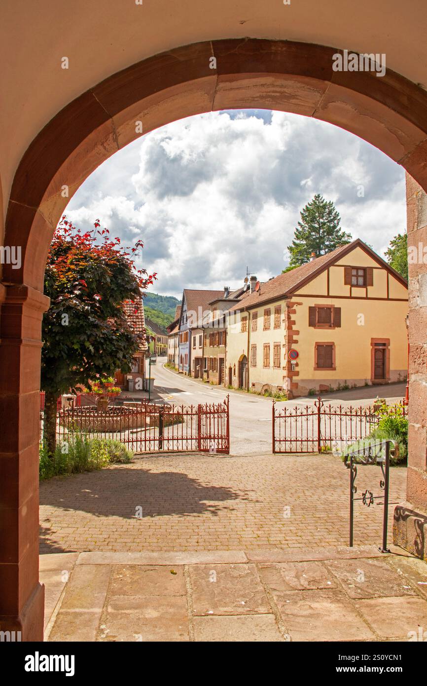 Rue du village Maisonsgoutte, vue du porche d'entrée de l'église Saint-Antoine. Bas-Rhin Banque D'Images