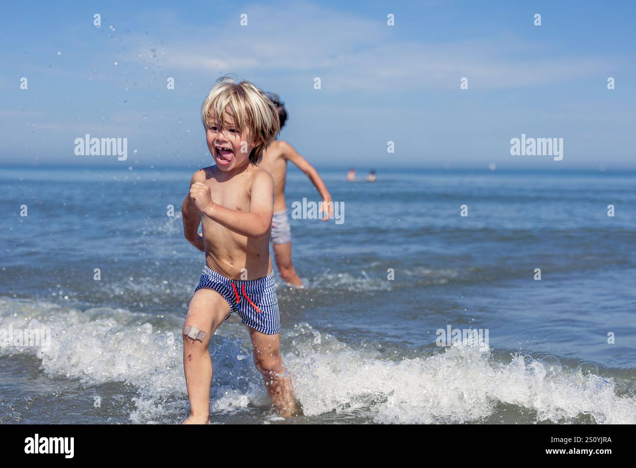 Pure Bliss : les enfants jouent dans les vagues de l'océan Banque D'Images