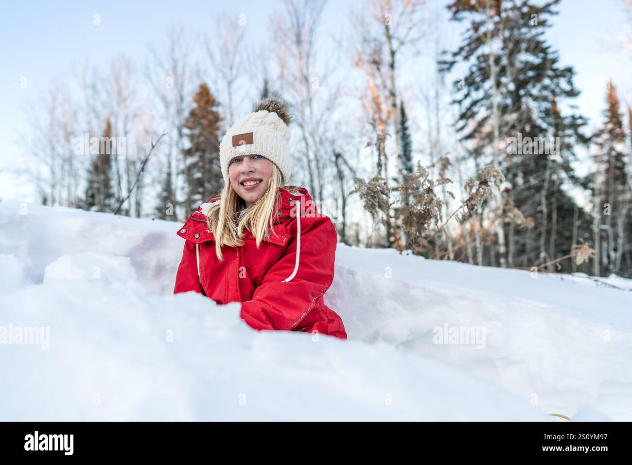 Enfant heureux en veste rouge jouant dans la neige Banque D'Images