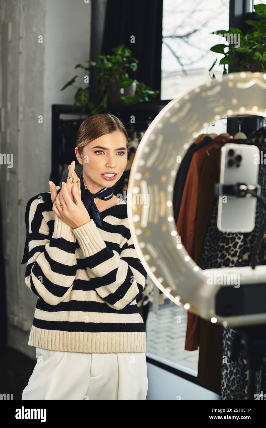 Une jeune femme à la mode présente sa tenue et ses bagues tout en créant un contenu attrayant pour les adeptes. Banque D'Images