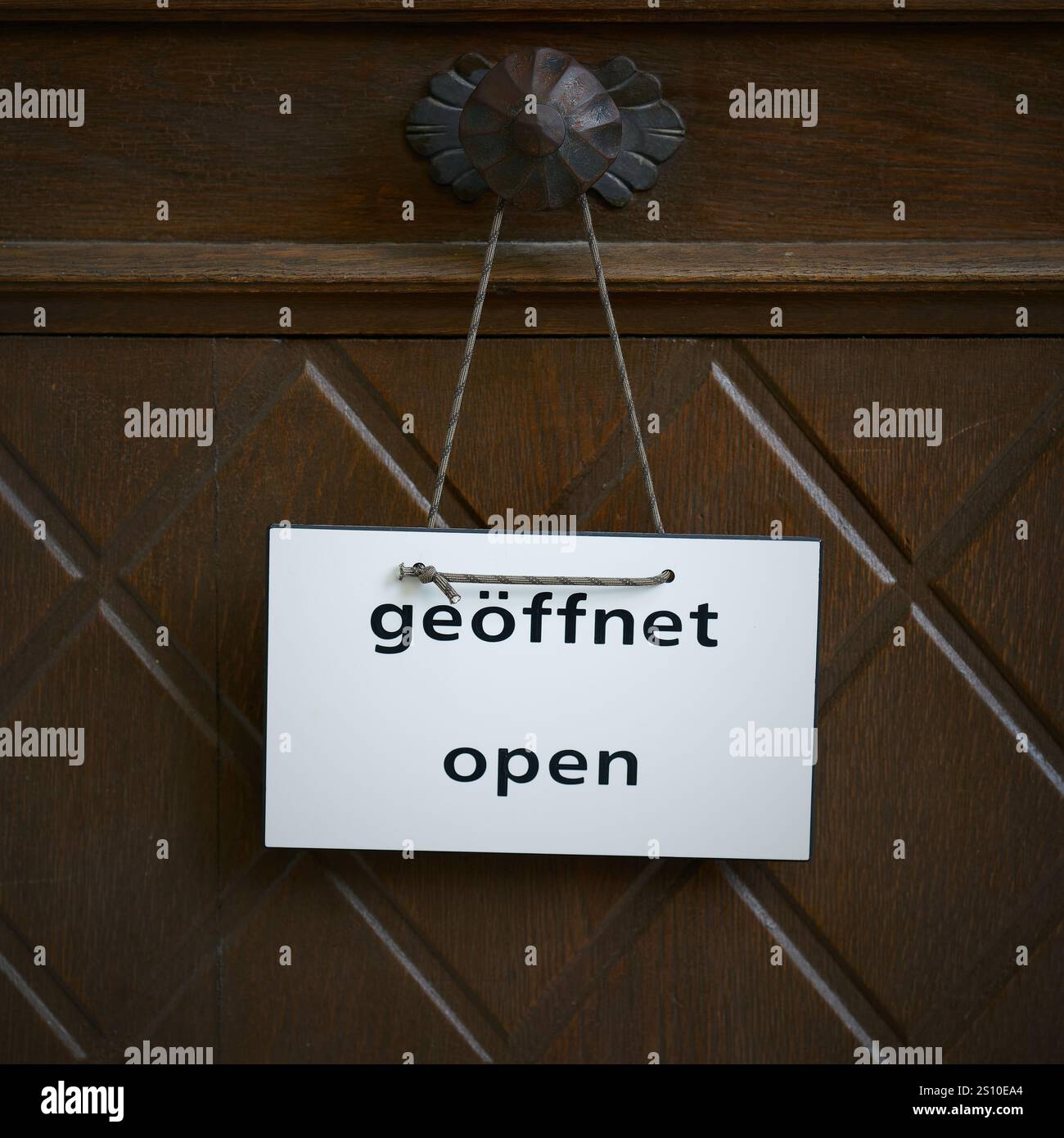 Signe sur une porte d'entrée de avec le mot Open, geoffnet en allemand et en anglais Banque D'Images