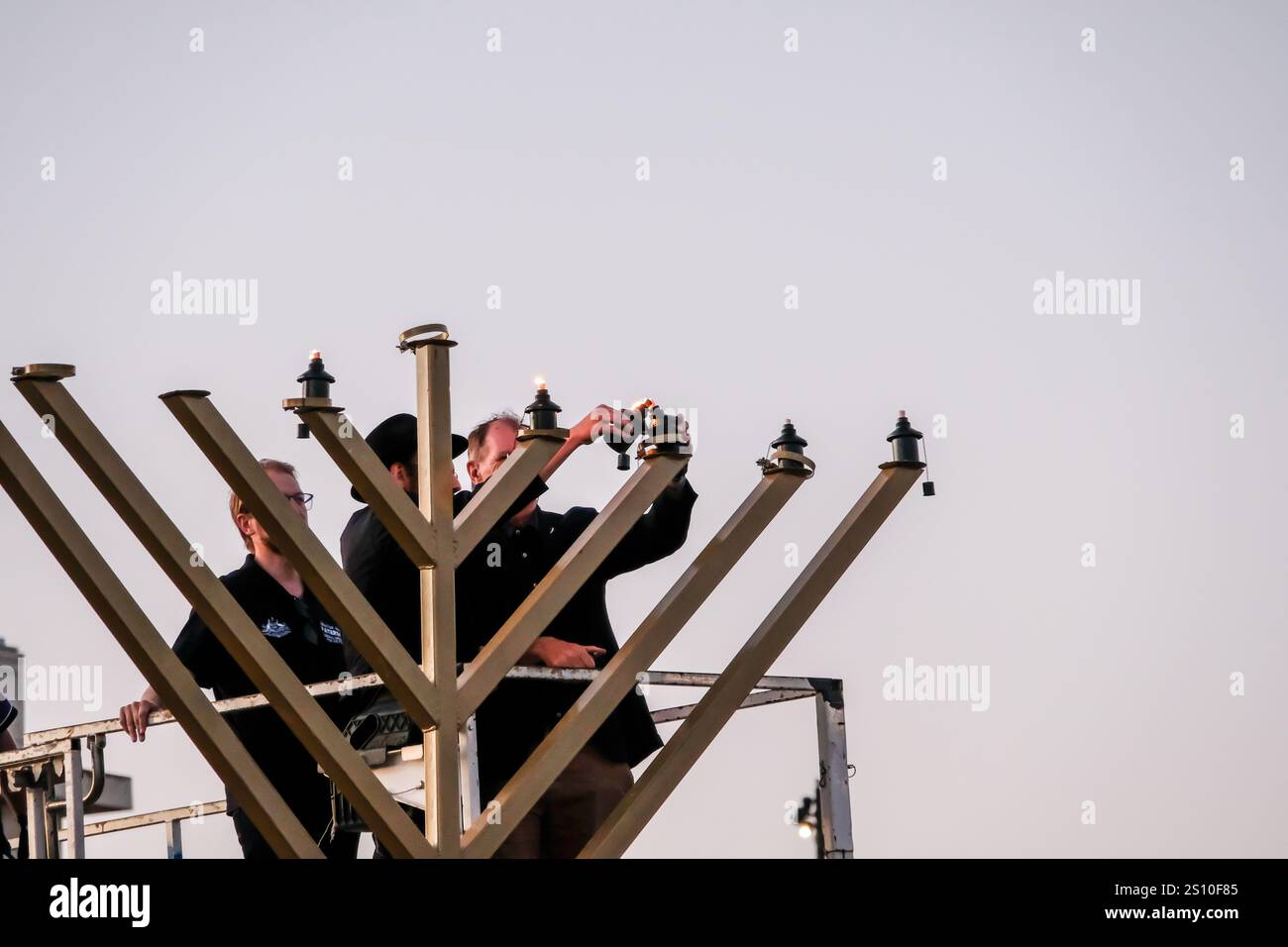 Melbourne, Australie. 29 décembre 2024. Le ministre fantôme australien des Affaires intérieures, le sénateur James Paterson (à gauche), le député victorien David Southwick (à droite) et le rabbin local sont vus allumer une menorah pendant la célébration de la fête juive Hanukkah à l'hippodrome de Caulfield à Melbourne. (Photo de Alexander Bogatyrev/SOPA images/SIPA USA) crédit : SIPA USA/Alamy Live News Banque D'Images