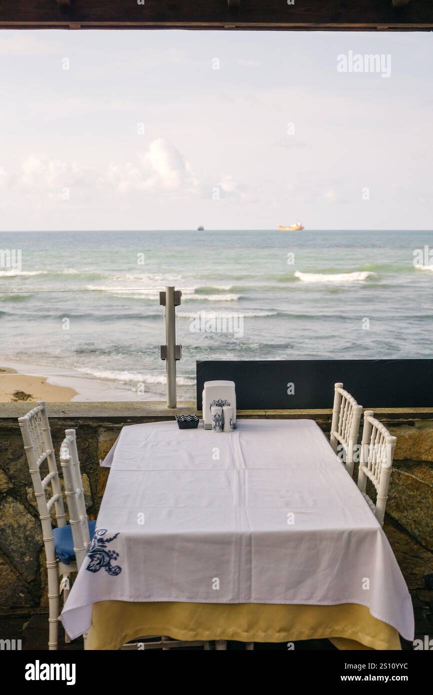 table à manger avec une nappe blanche sur le fond de la mer noire. table avec vue sur la baie Banque D'Images