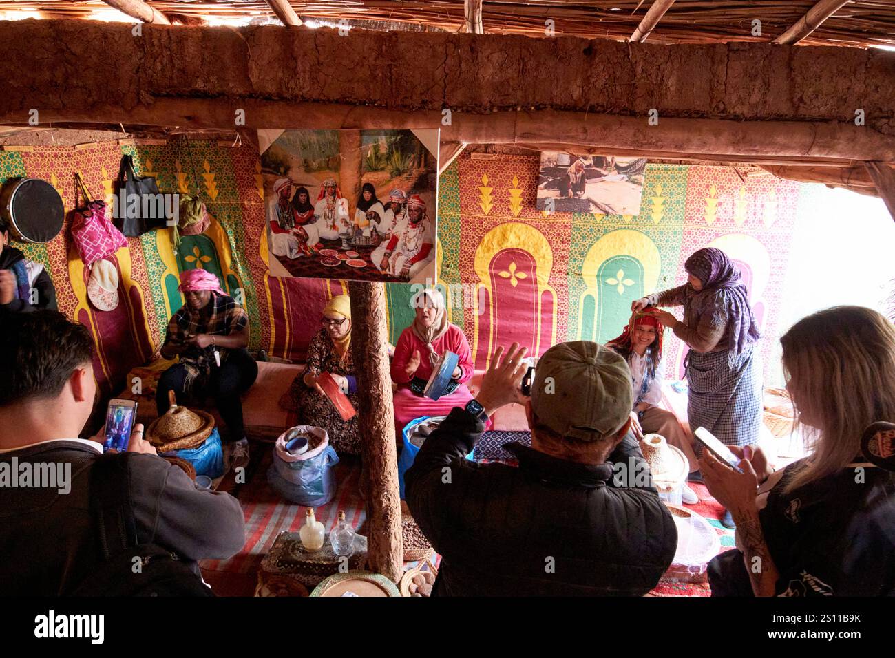 touristes visitant un collectif d'argan pour femmes dans une maison berbère traditionnelle à ossature de boue et de bois à azrou maroc Banque D'Images