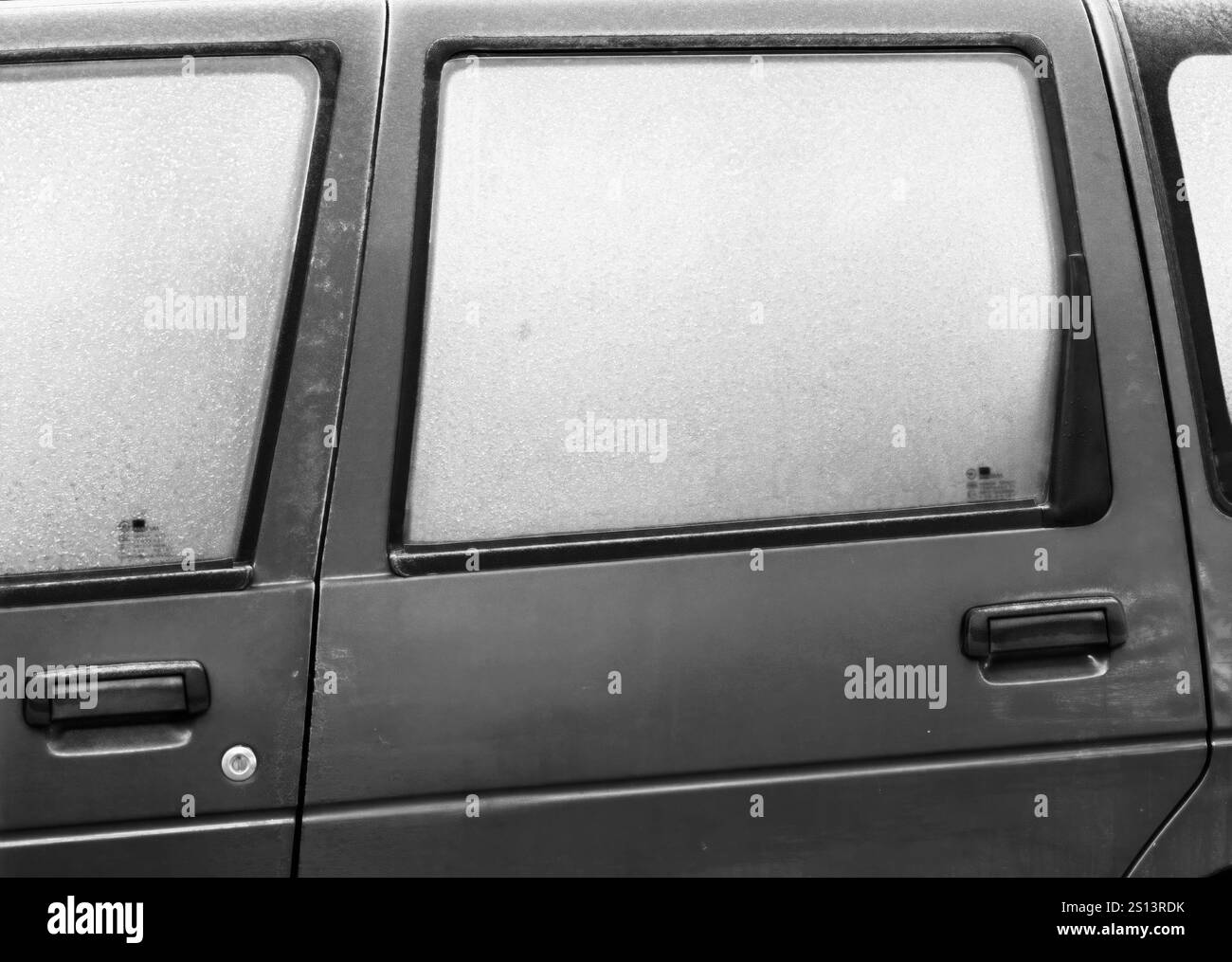 Motifs gelés : verre givré et poignée d'une voiture garée Banque D'Images