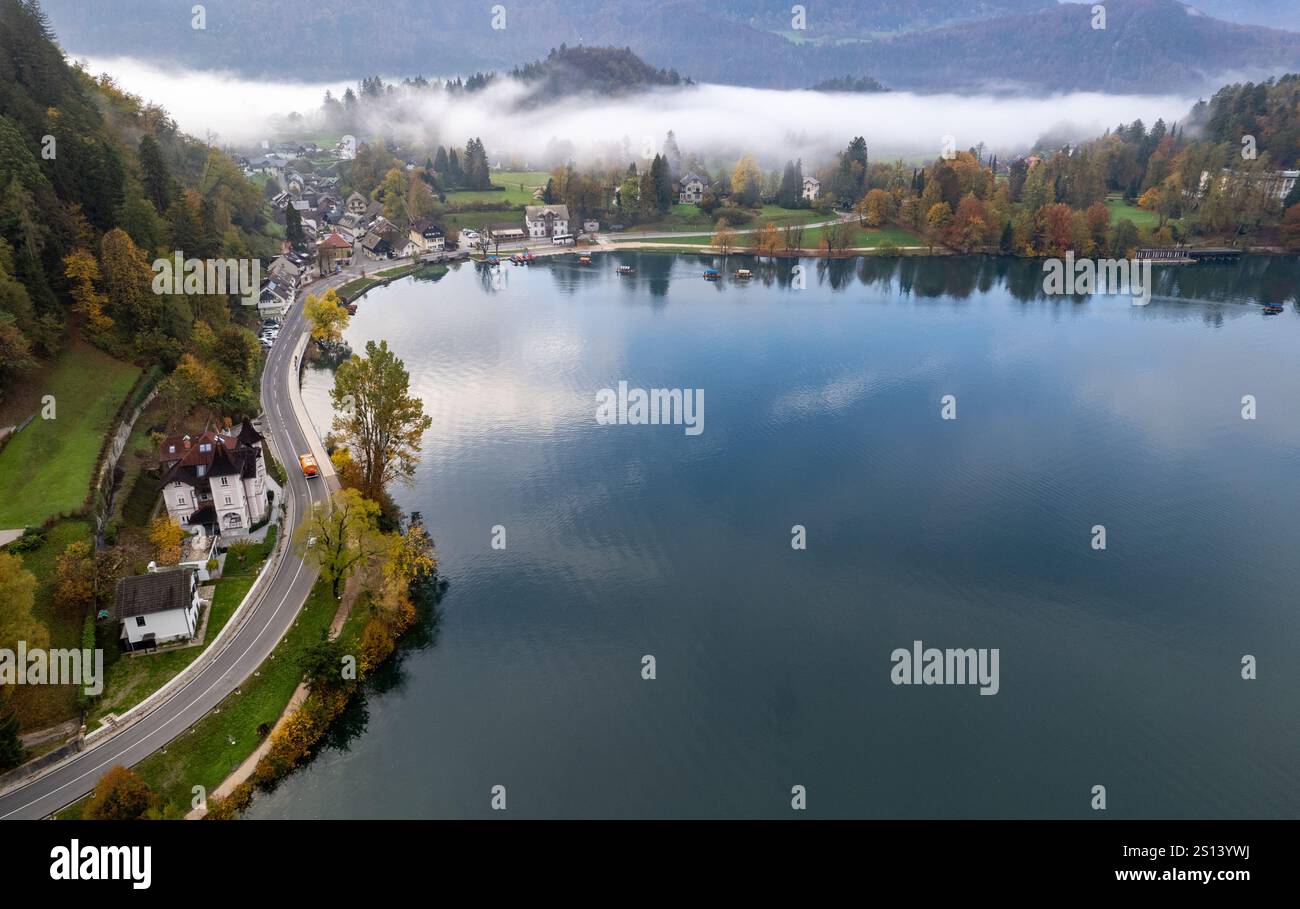 Vue aérienne du brouillard roulant sur l'île de Bled sur le lac Bled, slovénie, pendant un automne coloré Banque D'Images