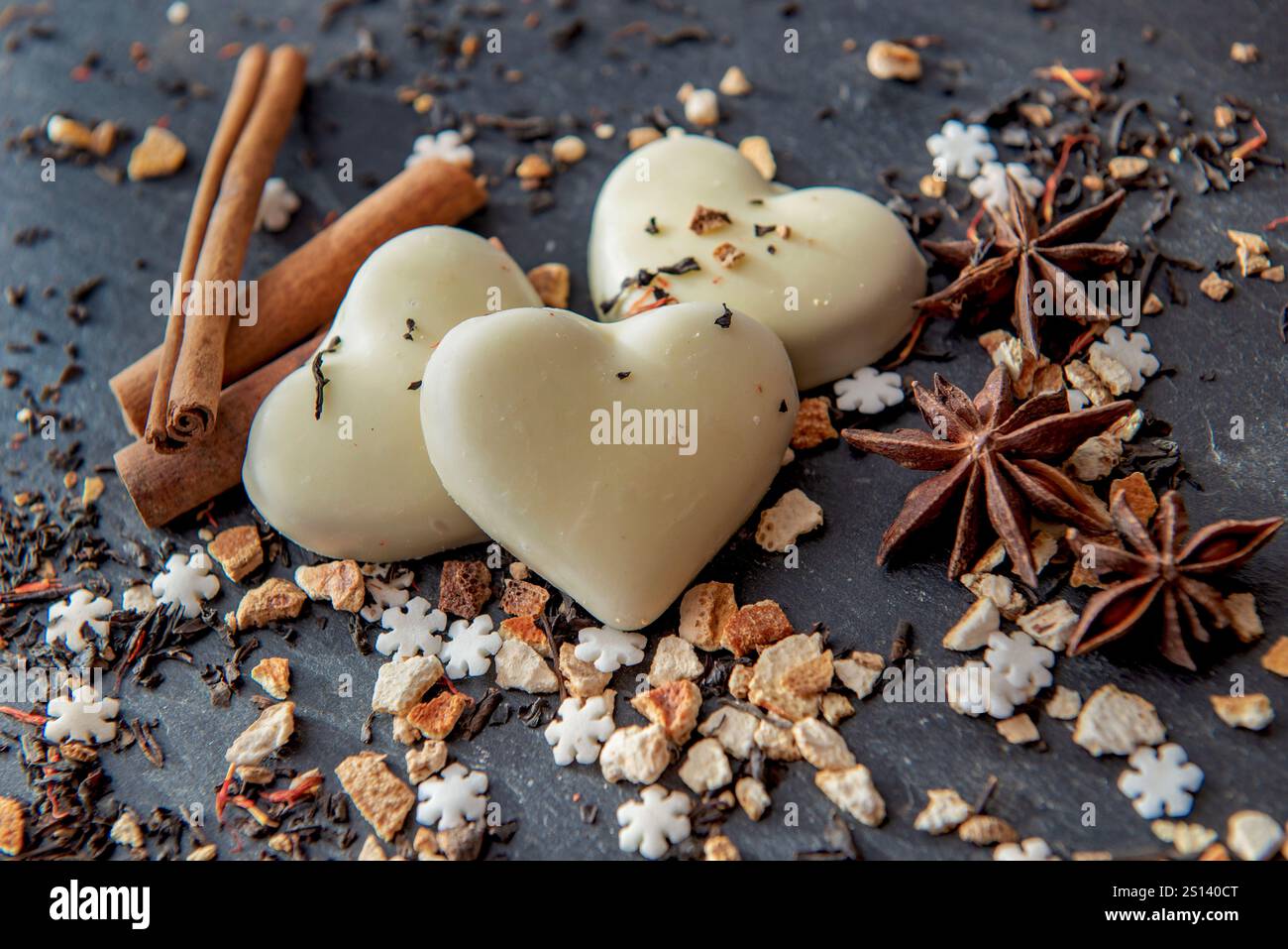 vue de dessus sur des biscuits en forme de coeur et des épices disposés sur un fond d'ardoise grise Banque D'Images
