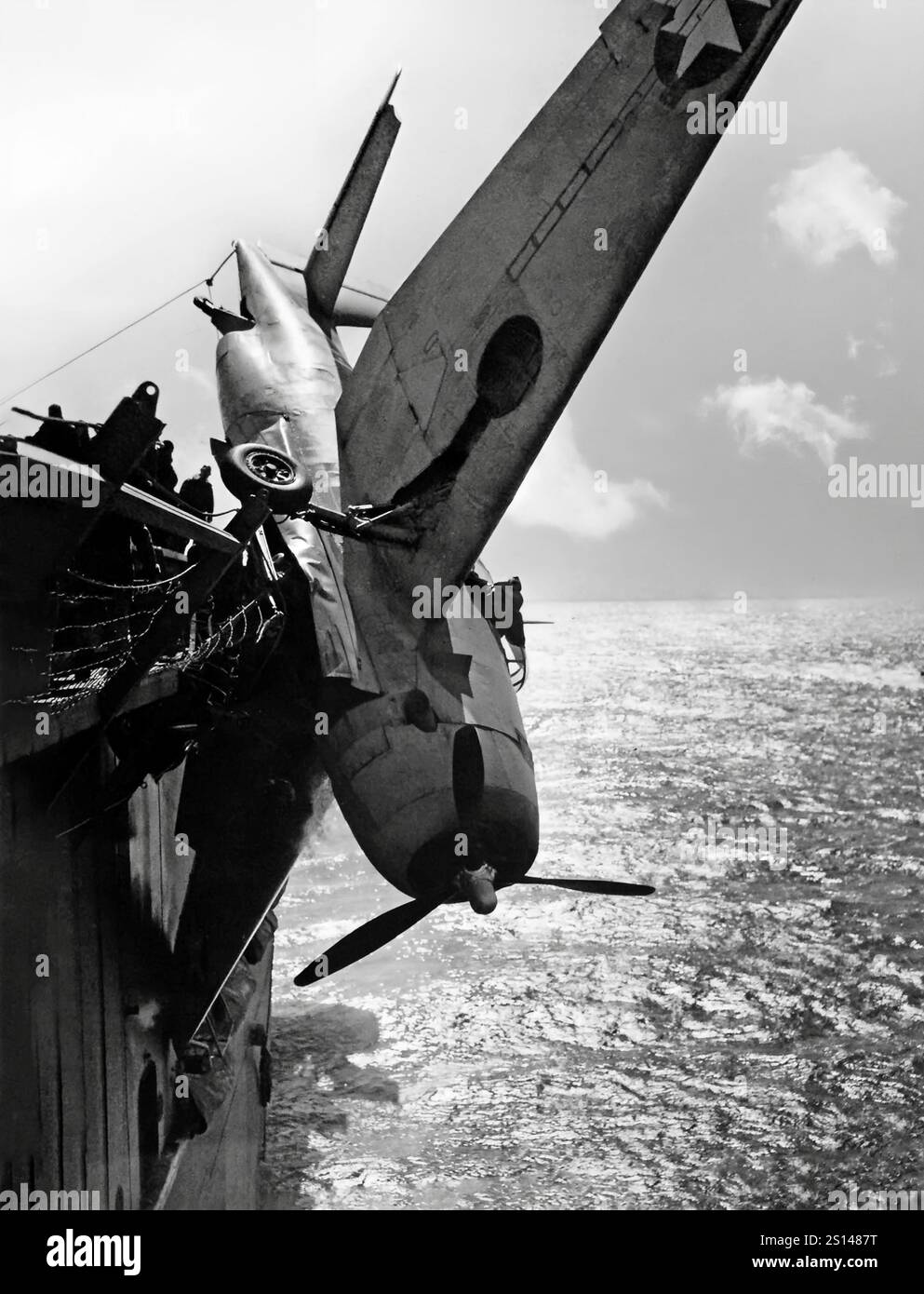 Un Grumman TBF Avenger suspendu au-dessus de la mer suite à un atterrissage accidenté de porte-avions. Un bombardier-torpilleur américain datant de la seconde Guerre mondiale a été développé initialement pour la marine américaine et le corps des Marines, mais a finalement été utilisé par plusieurs services aériens et navals dans le monde entier. Il entra en service aux États-Unis en 1942 et participa pour la première fois à la bataille de Midway. Malgré la perte de cinq des six Avengers lors de ses débuts au combat, il survit en service pour devenir le bombardier-torpilleur le plus utilisé de la IIe Guerre mondiale Banque D'Images
