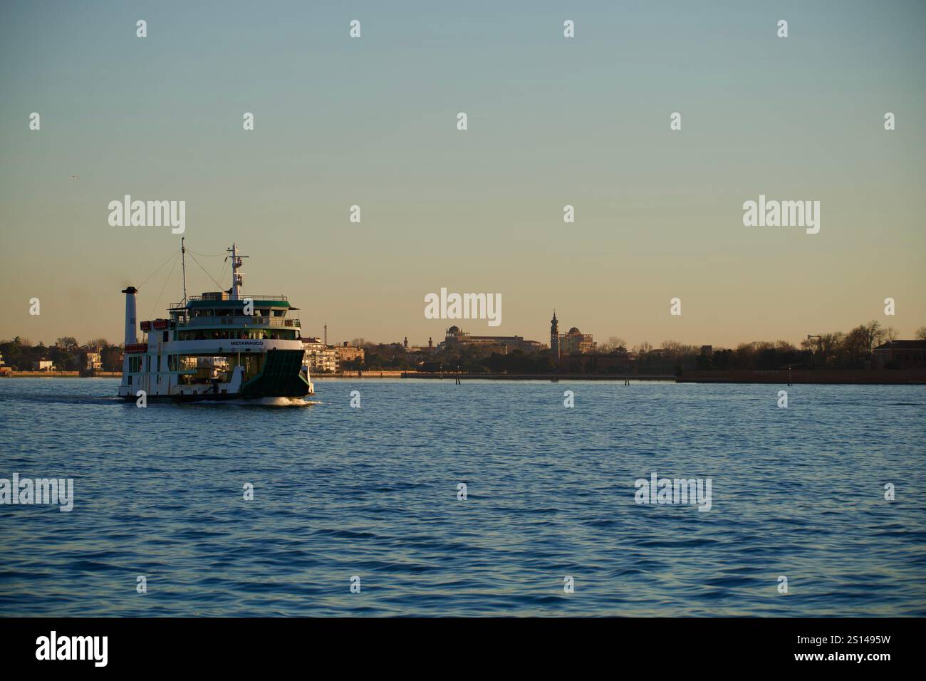 Venise, Italie. 27 décembre 2024. Un navire se déplace pendant un coucher de soleil. Banque D'Images