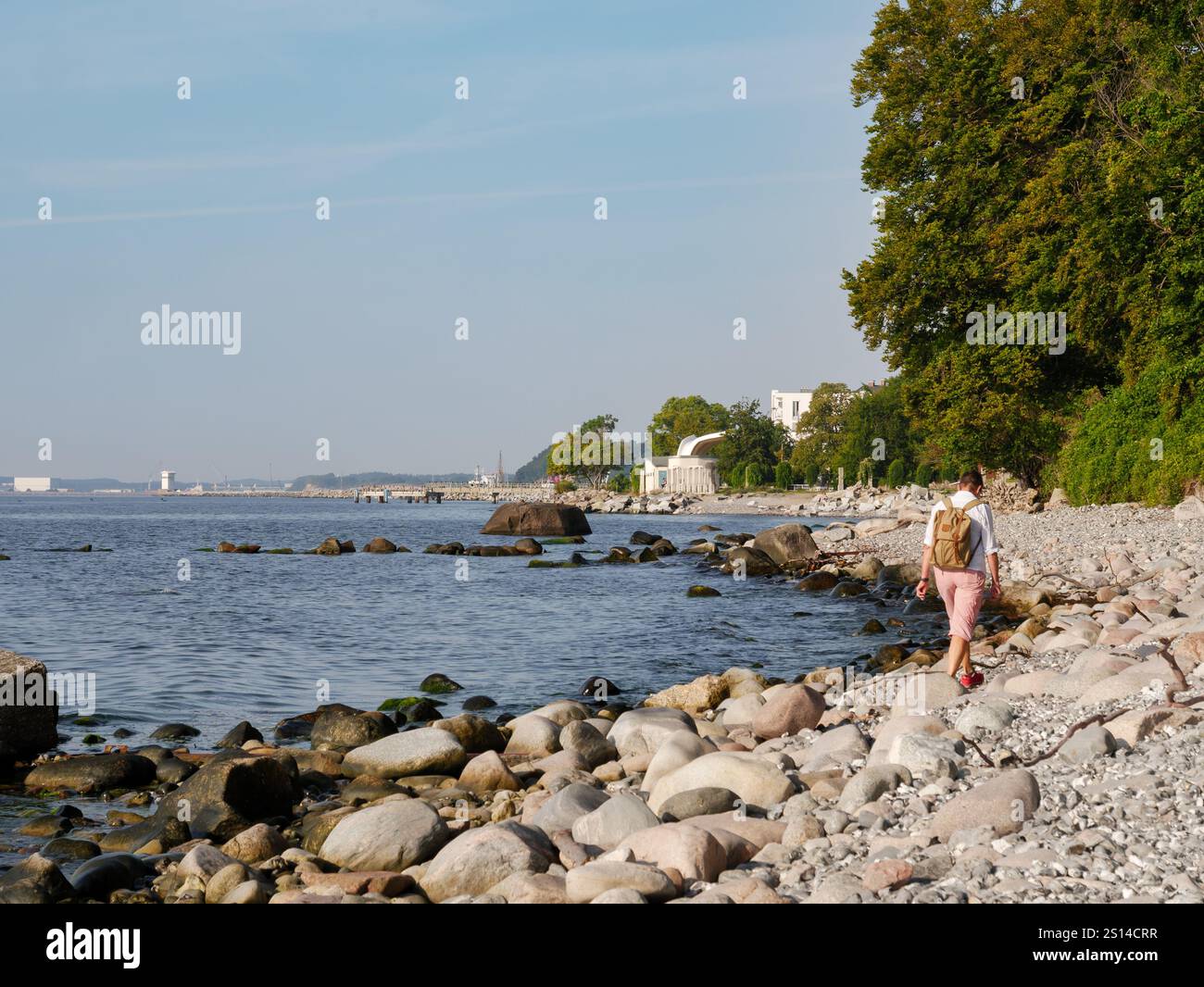 Vue arrière d'une femme marchant sur la plage de galets près de Sassnitz, Jasmund NP, île de Rügen, Mecklembourg-Poméranie occidentale, Allemagne Banque D'Images