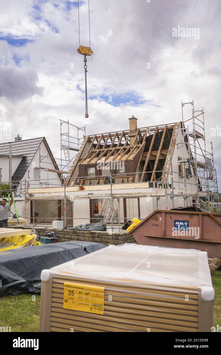 Travaux de rénovation avec treillis de toit exposé, échafaudage et grue au-dessus d'une maison Banque D'Images