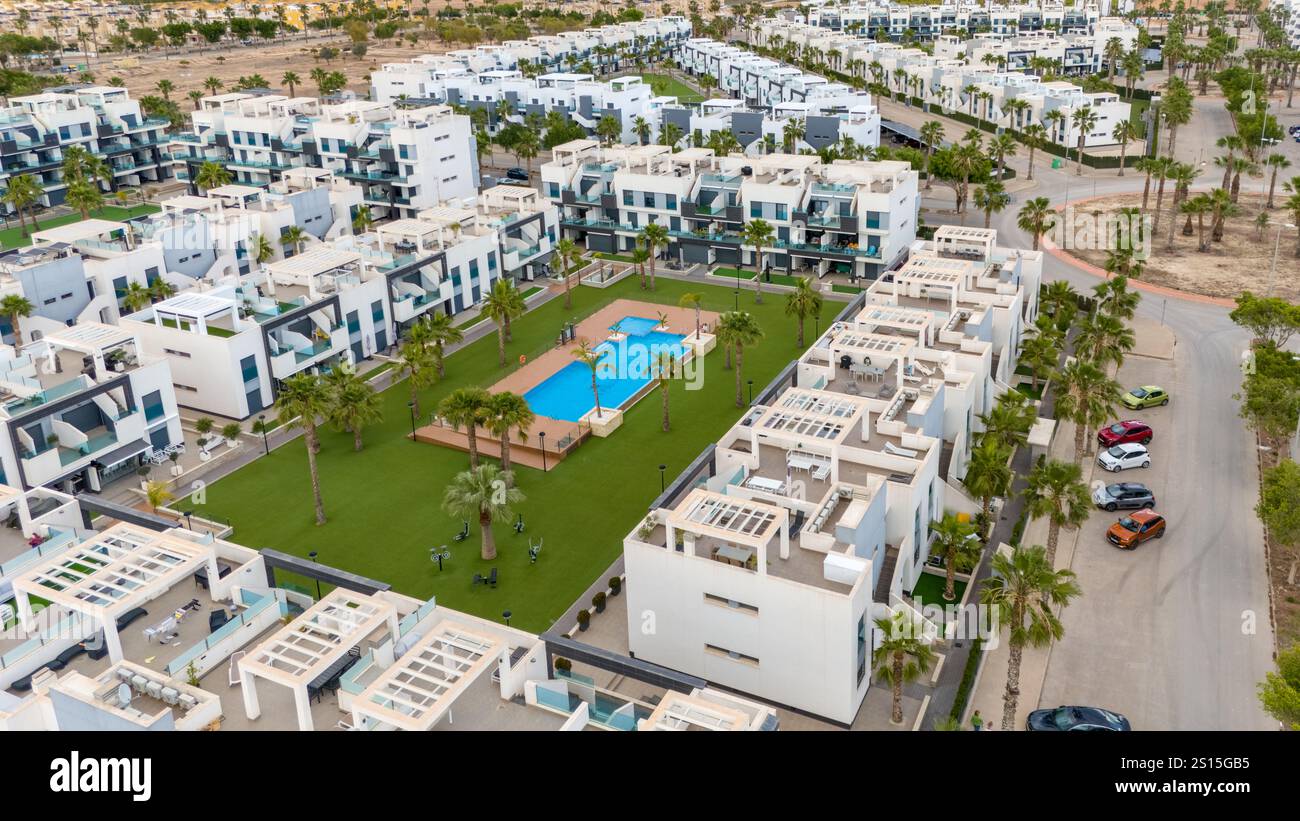 Vue aérienne d''un complexe d''appartements contemporains sur la Costa Blanca, en Espagne, doté d''une cour paysagée et d''une piscine centrale. Banque D'Images