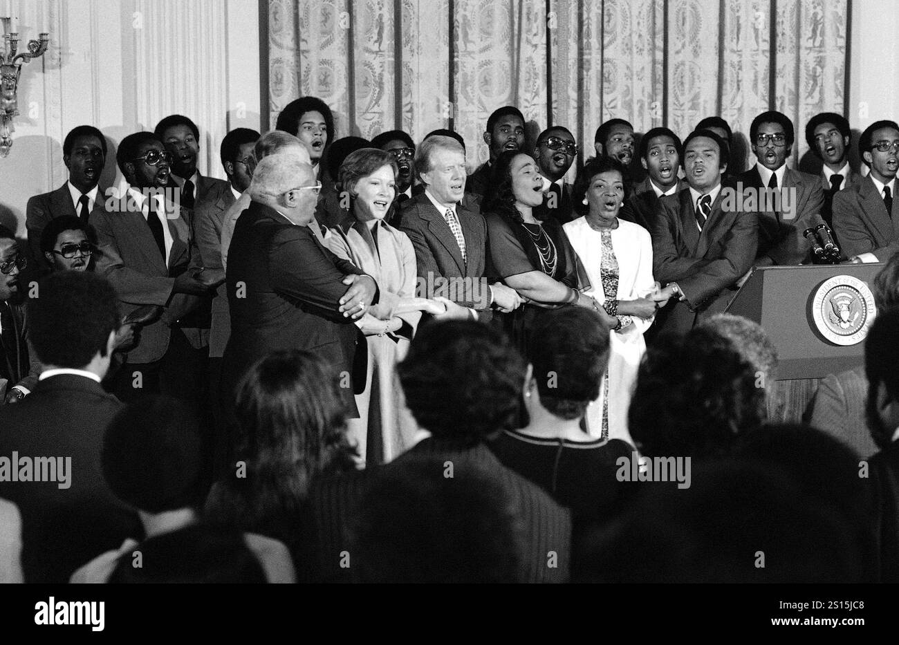 FILE - Dr. Martin Luther King Sr., Rosalynn Carter, President Jimmy Carter, Coretta Scott King, Christine Parris King, sister of the late Dr. King, and U.N. Ambassador Andrew Young sing during a reception honoring friends of the Martin Luther King Jr. Center for Social Change in Washington on Oct. 3, 1978. (AP Photo/Barry Thumma, File) Banque D'Images