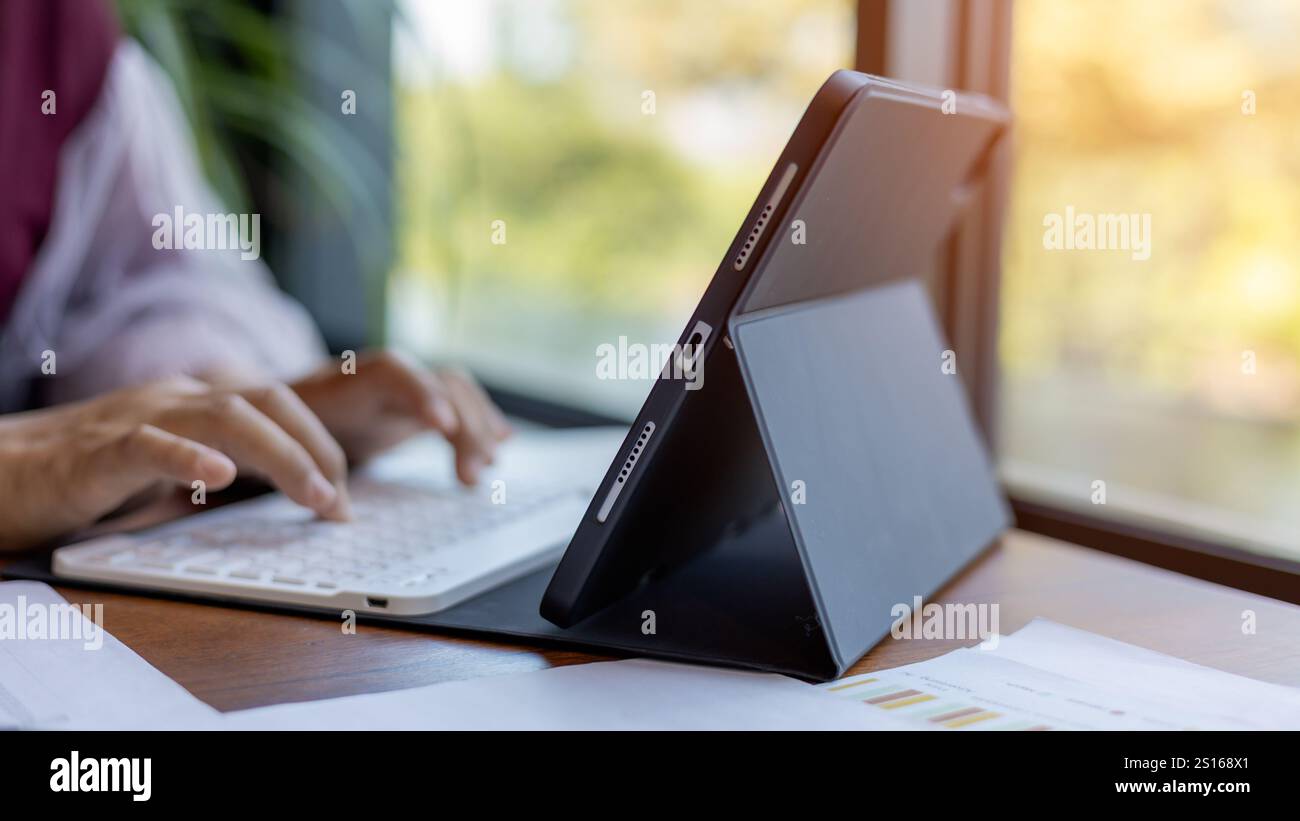 Les mains féminines tapant sur le clavier de la tablette sur le bureau en bois au bureau, technologie, concept d'affaires, femme d'affaires analyser le graphique de l'entreprise performan Banque D'Images