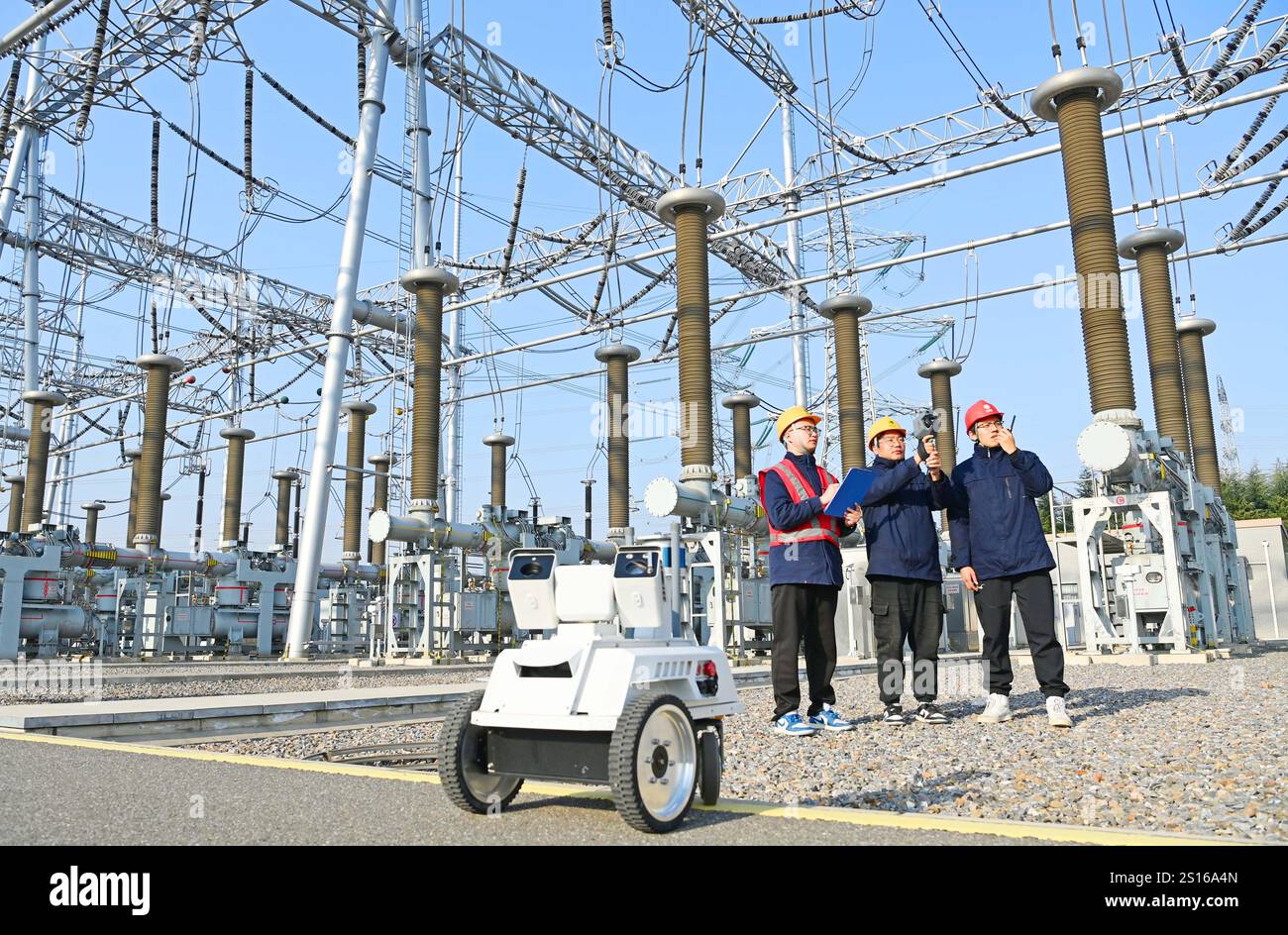 CHUZHOU, CHINE - 1er JANVIER 2025 - Un robot intelligent 5G et du personnel d'exploitation et de maintenance inspectent l'équipement d'alimentation principal en 50 Banque D'Images
