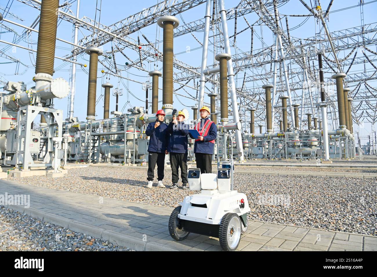 CHUZHOU, CHINE - 1er JANVIER 2025 - Un robot intelligent 5G et du personnel d'exploitation et de maintenance inspectent l'équipement d'alimentation principal en 50 Banque D'Images