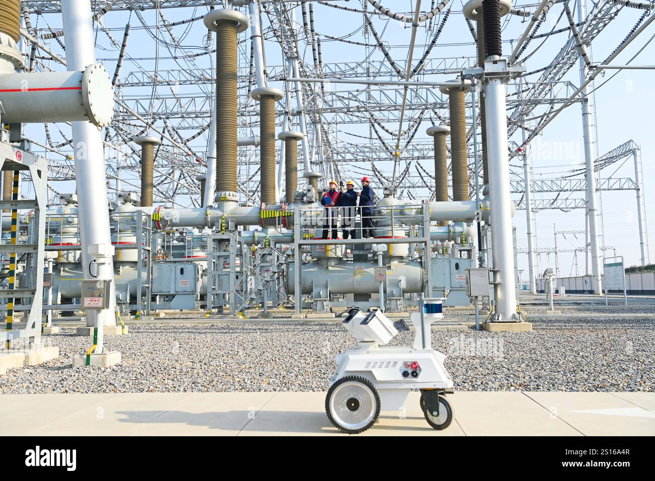 CHUZHOU, CHINE - 1er JANVIER 2025 - Un robot intelligent 5G et du personnel d'exploitation et de maintenance inspectent l'équipement d'alimentation principal en 50 Banque D'Images