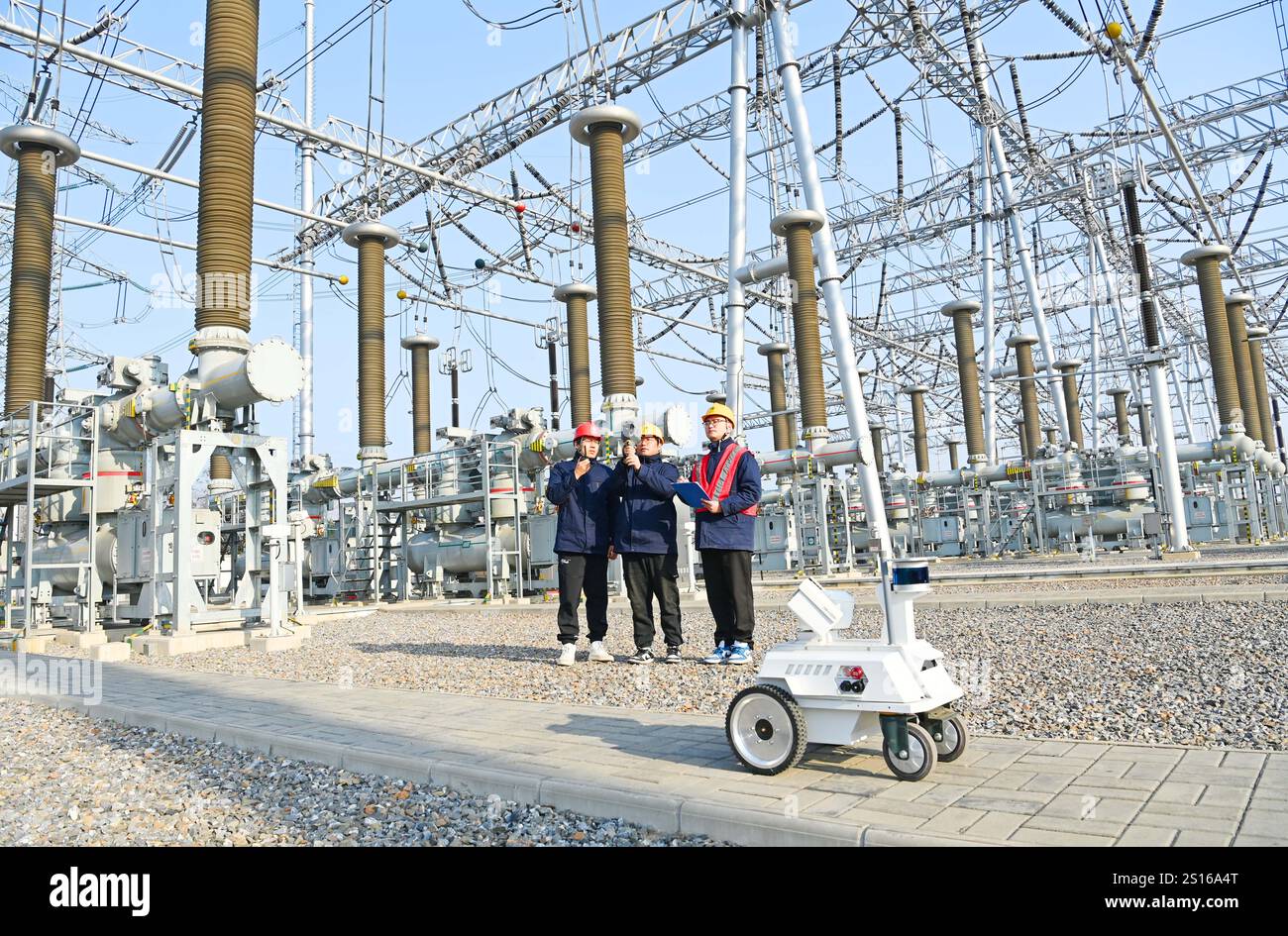 CHUZHOU, CHINE - 1er JANVIER 2025 - Un robot intelligent 5G et du personnel d'exploitation et de maintenance inspectent l'équipement d'alimentation principal en 50 Banque D'Images