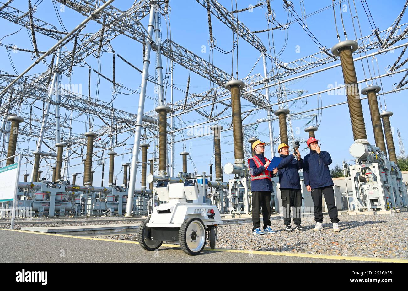 CHUZHOU, CHINE - 1er JANVIER 2025 - Un robot intelligent 5G et du personnel d'exploitation et de maintenance inspectent l'équipement d'alimentation principal en 50 Banque D'Images