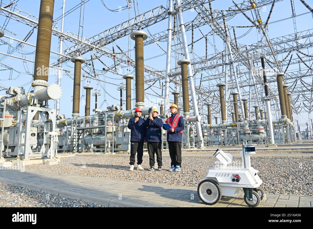 CHUZHOU, CHINE - 1er JANVIER 2025 - Un robot intelligent 5G et du personnel d'exploitation et de maintenance inspectent l'équipement d'alimentation principal en 50 Banque D'Images