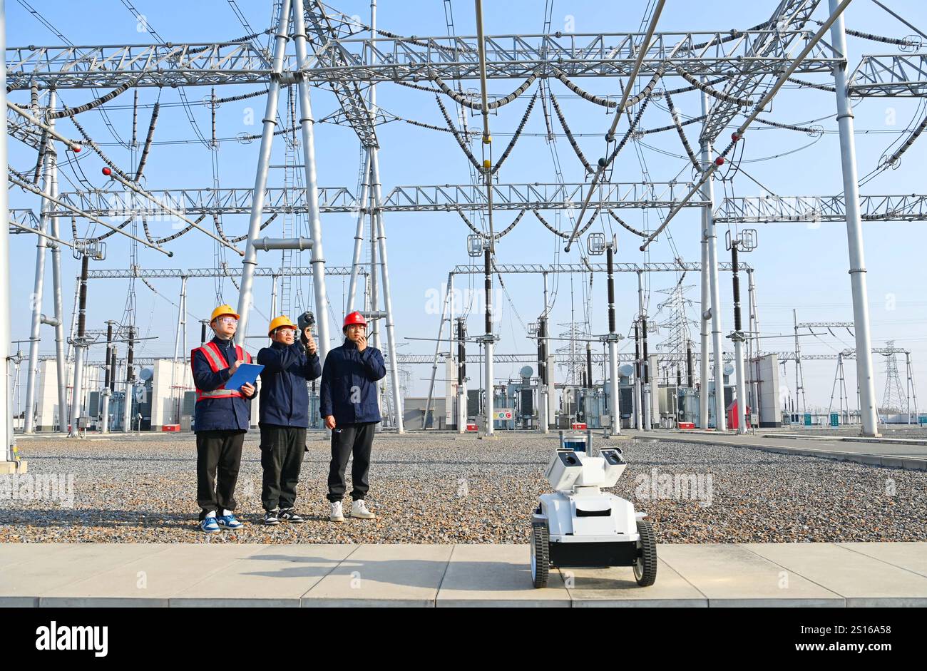 CHUZHOU, CHINE - 1er JANVIER 2025 - Un robot intelligent 5G et du personnel d'exploitation et de maintenance inspectent l'équipement d'alimentation principal en 50 Banque D'Images