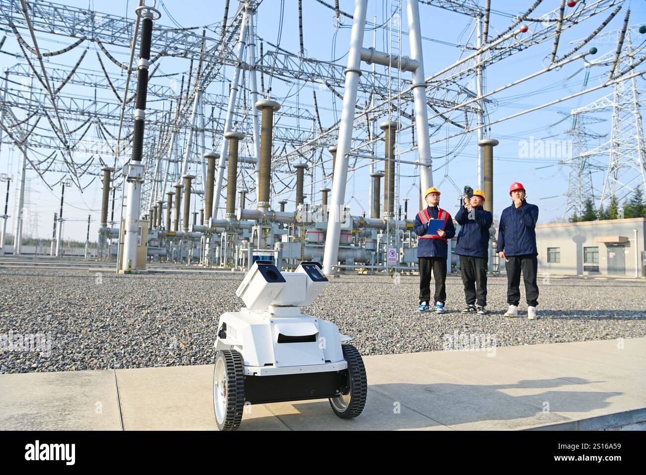CHUZHOU, CHINE - 1er JANVIER 2025 - Un robot intelligent 5G et du personnel d'exploitation et de maintenance inspectent l'équipement d'alimentation principal en 50 Banque D'Images