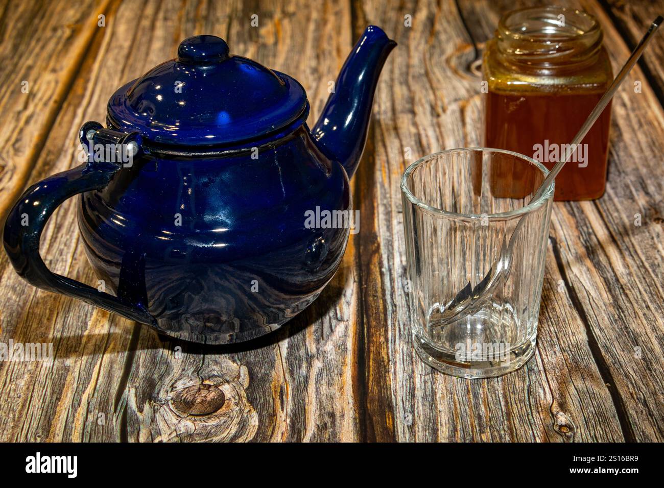 Théière et verre avec pot de miel placé sur la table Banque D'Images