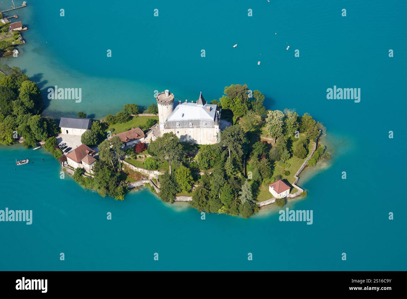 VUE AÉRIENNE.Château médiéval sur une péninsule dans les eaux turquoises du lac d'Annecy.Château de Duingt, haute-Savoie, France. Banque D'Images