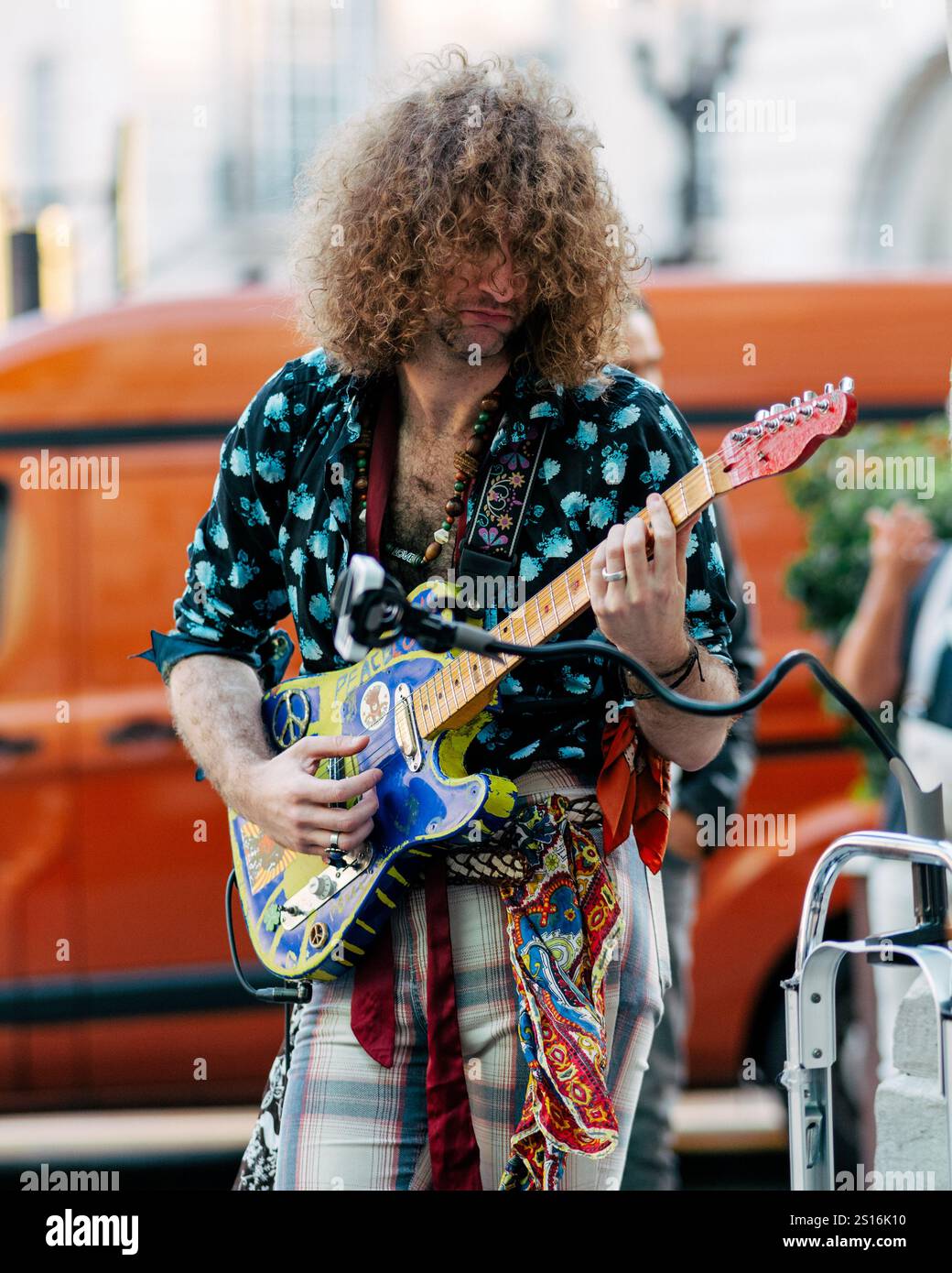 Un musicien joue de son instrument dans une rue animée, capturant une atmosphère énergique. Banque D'Images