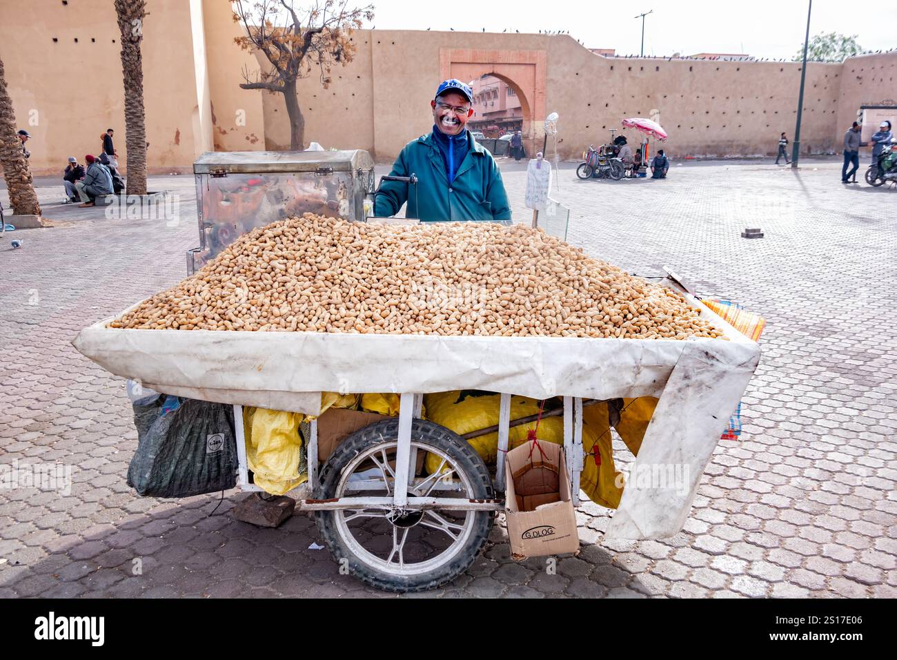 Marrakech, Maroc. Un vendeur souriant de noix de singe rôties avec des noix de singe entassées sur son chariot de poussée. Les noix sont pré-torréfiées puis réchauffées pour être vendues Banque D'Images