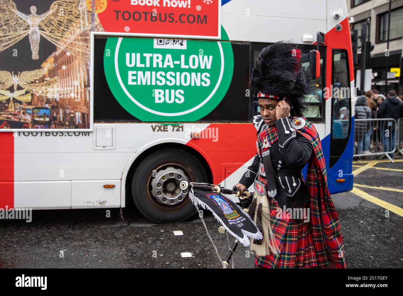 Londres, Royaume-Uni, 1er janvier 2025. Un membre du groupe ajuste son chapeau devant London Bus. Des milliers de spectateurs bravent les vents forts et lourds pour assister à la parade annuelle du jour de l'an 2025 à Londres. Crédit : James Willoughby/ALAMY Live News Banque D'Images