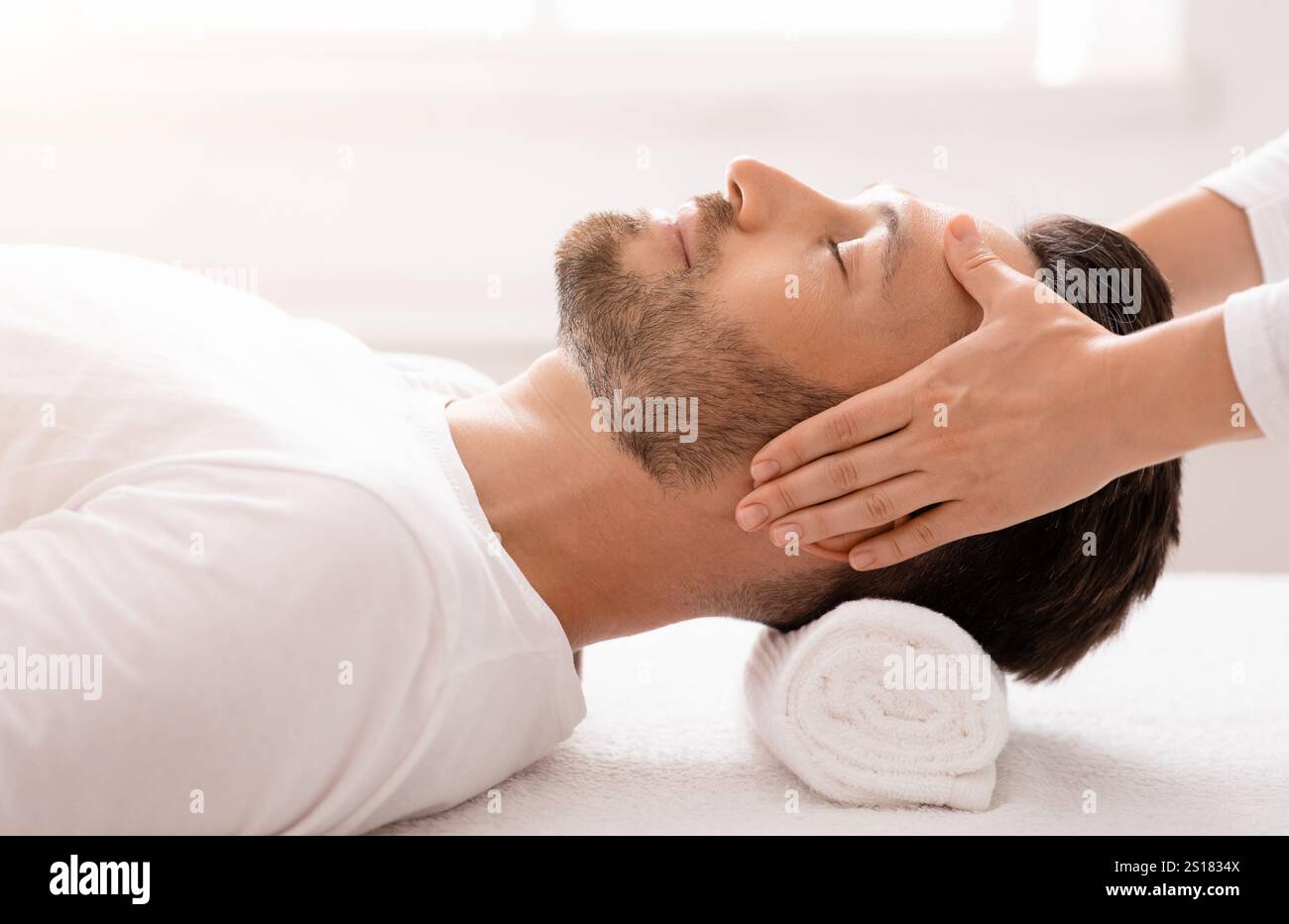Femme thérapeute faisant un massage relaxant de la tête pour l'homme beau Banque D'Images