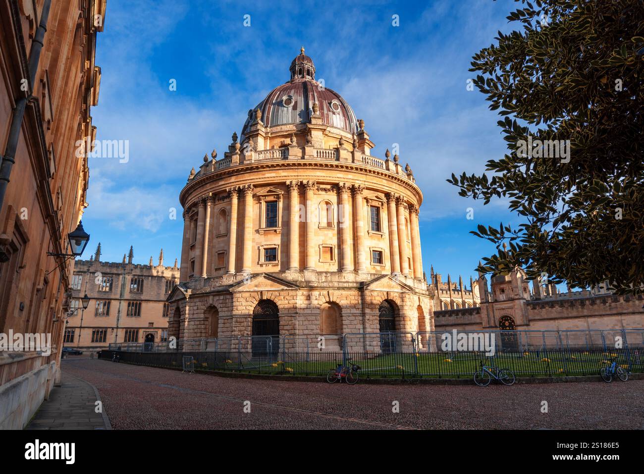 Oxford, Royaume-Uni - Radcliffe caméra baignée de lumière dorée, mettant en valeur l'architecture néoclassique historique et le charme académique environnant par temps clair Banque D'Images
