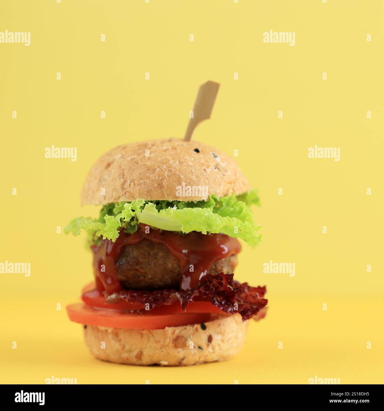 Mini hamburger avec Burger de bœuf, laitue et tomate, sur fond jaune Banque D'Images