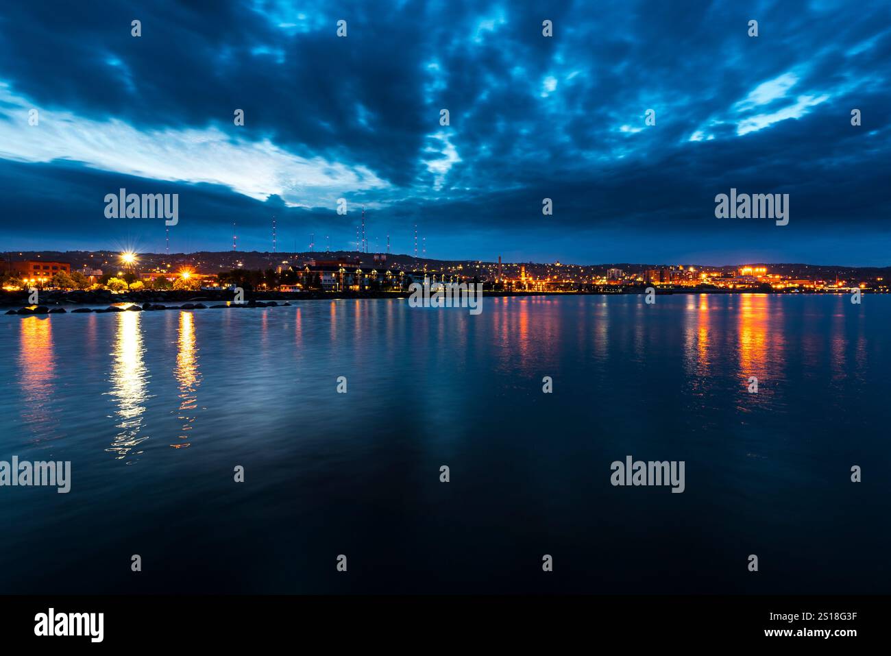 Paysage urbain pittoresque au bord de l'eau la nuit avec reflets vibrants sur l'eau Banque D'Images
