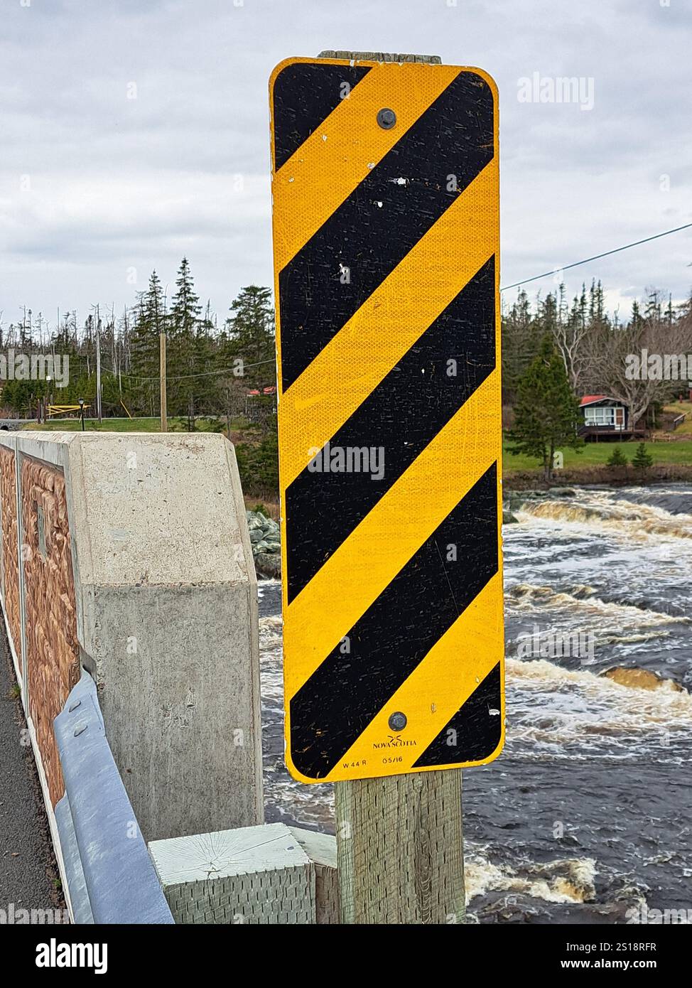 Panneau de danger rectangulaire jaune et noir à rayures diagonales sur un pont à Liscomb, Nouvelle-Écosse, Canada Banque D'Images