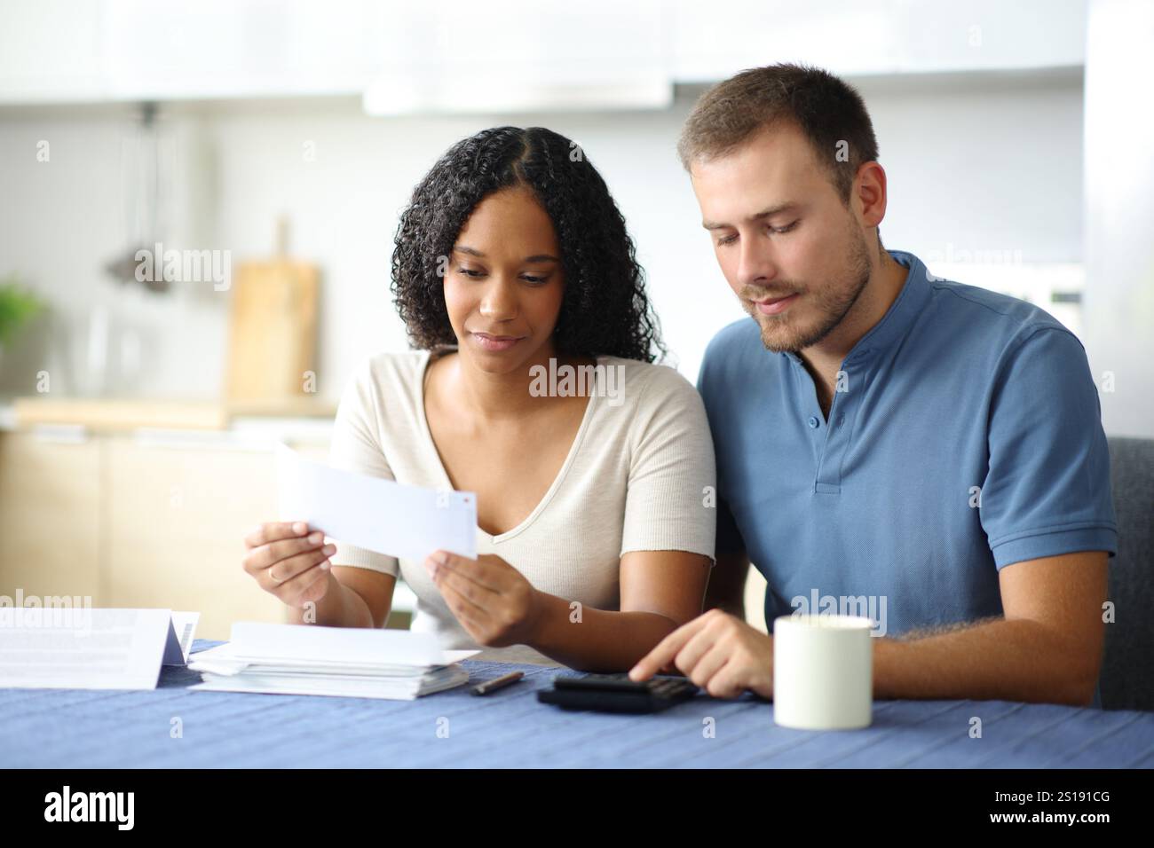 Couple interracial calculant les dépenses dans la cuisine à la maison Banque D'Images