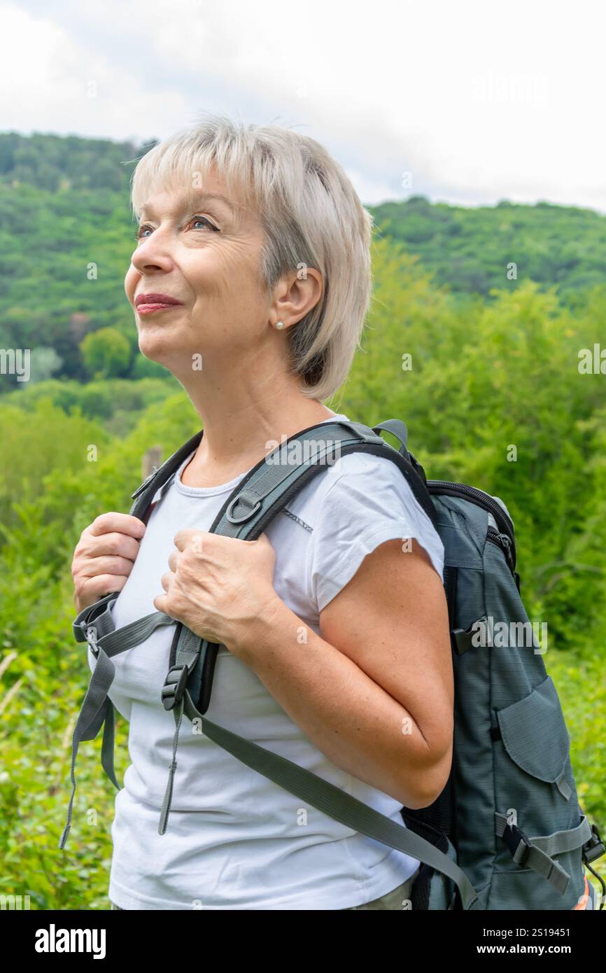 Une femme âgée active aime une randonnée dans les montagnes. Banque D'Images