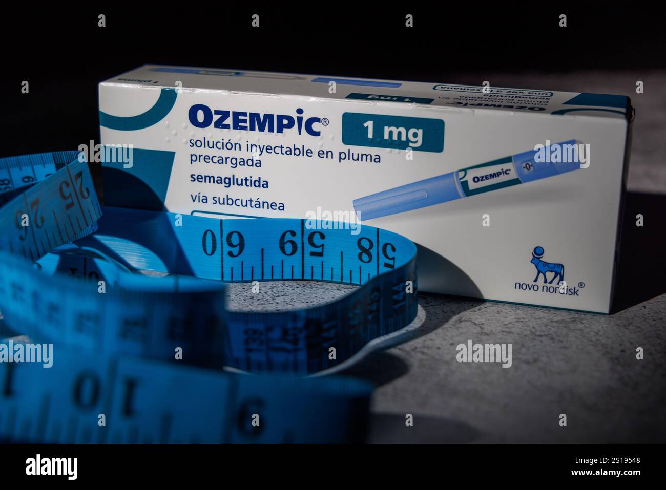 Médicament de perte de poids Ozempic et ruban à mesurer sur une surface en béton, éclairé par une lumière unique pour une présentation ciblée Banque D'Images