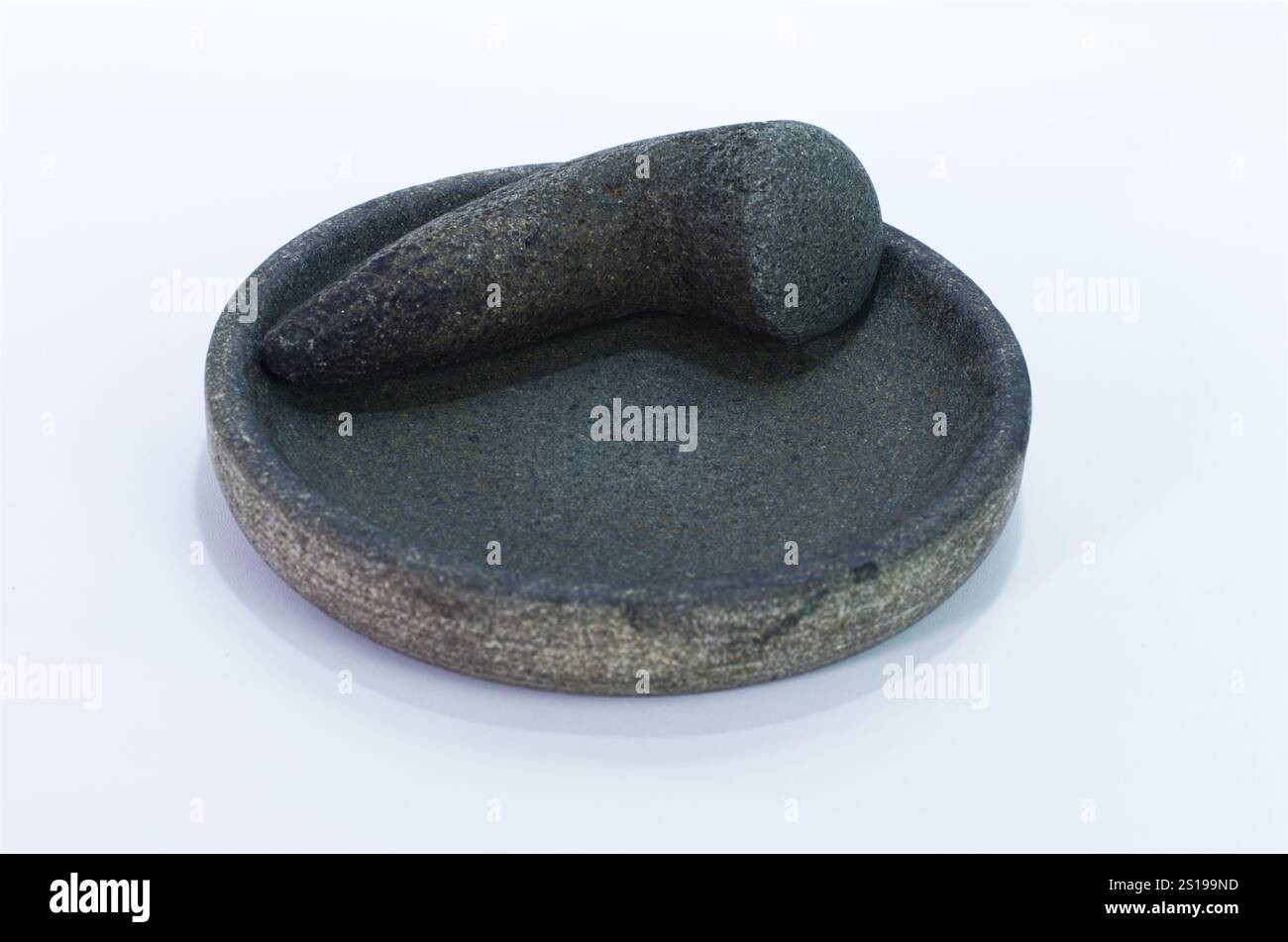 Mortier de pierre traditionnel et pilon pour la préparation des aliments sur un fond blanc Banque D'Images