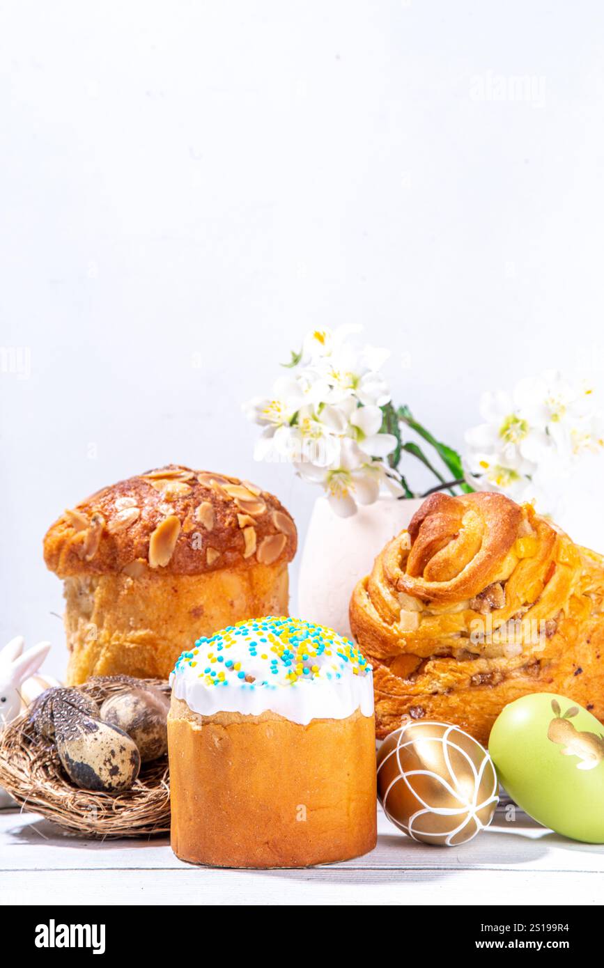 Fond de cuisson de Pâques avec des gâteaux de vacances traditionnels - kraffin, panettone, paska kulich, avec des œufs de Pâques, fleurs de printemps sur une table en bois blanc, sp Banque D'Images