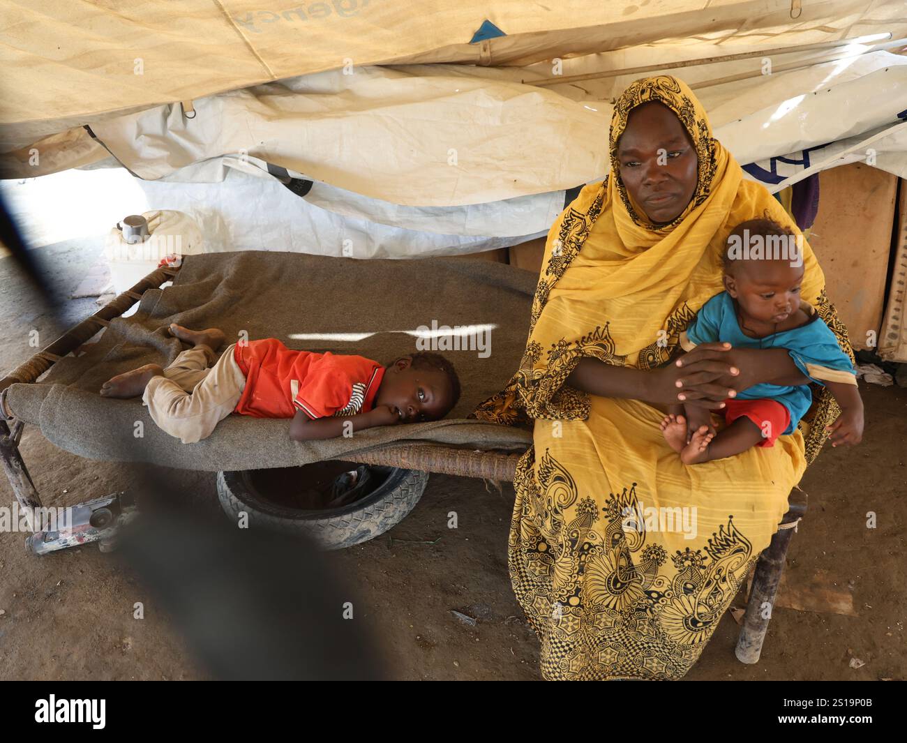 Pékin, Soudan. 12 novembre 2024. Une femme avec deux enfants repose dans une tente dans un centre pour personnes déplacées à Port Soudan, État de la mer Rouge, Soudan oriental, le 12 novembre 2024. Les combats entre les Forces armées soudanaises et les Forces paramilitaires de soutien rapide, qui ont commencé à la mi-avril 2023, ont tué plus de 28 700 personnes. Crédit : Fayez Ezaki/Xinhua/Alamy Live News Banque D'Images