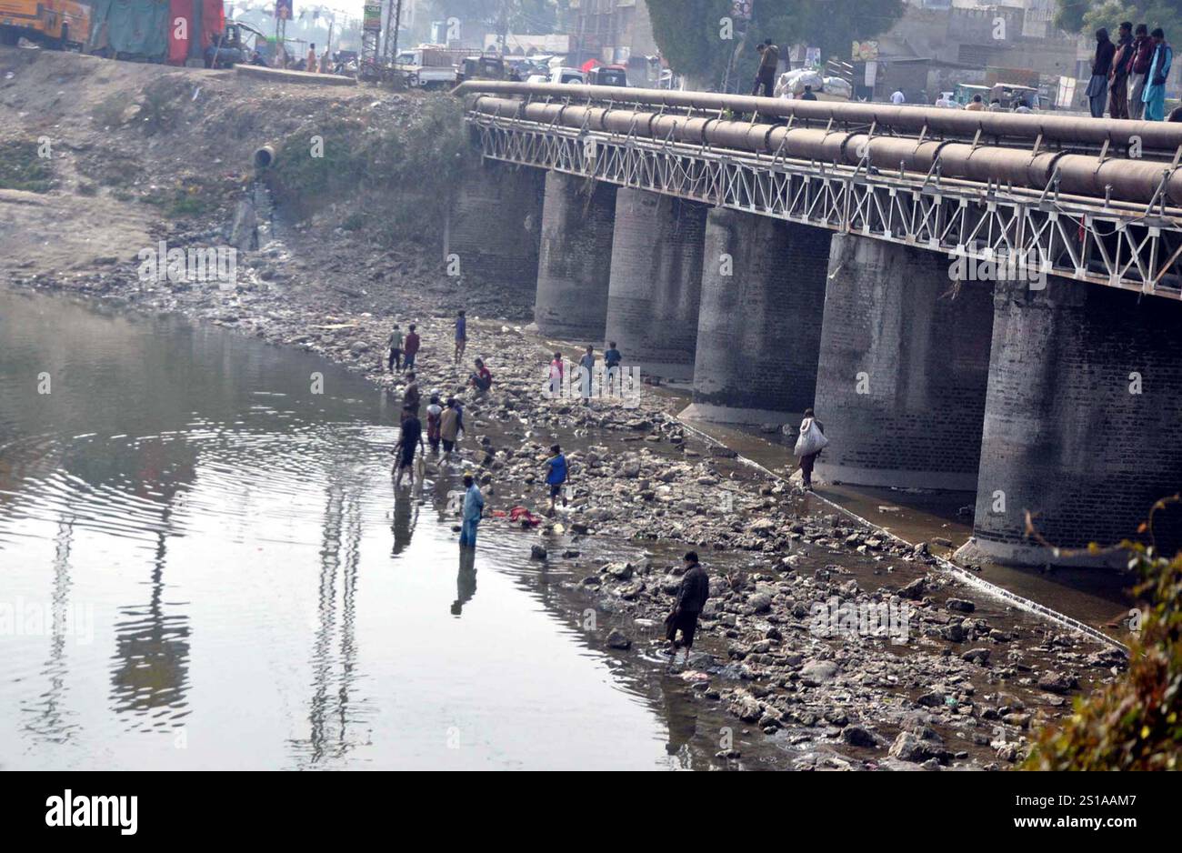 Vue sur le canal de Pinyari asséchée alors que le département d’irrigation commence une fermeture annuelle de 15 jours de tous les canaux du Sindh pour nettoyage tandis que les pêcheurs locaux chassent le poisson pour gagner leur vie pour subvenir aux besoins de leurs familles, à Hyderabad le jeudi 2 janvier 2025. Banque D'Images