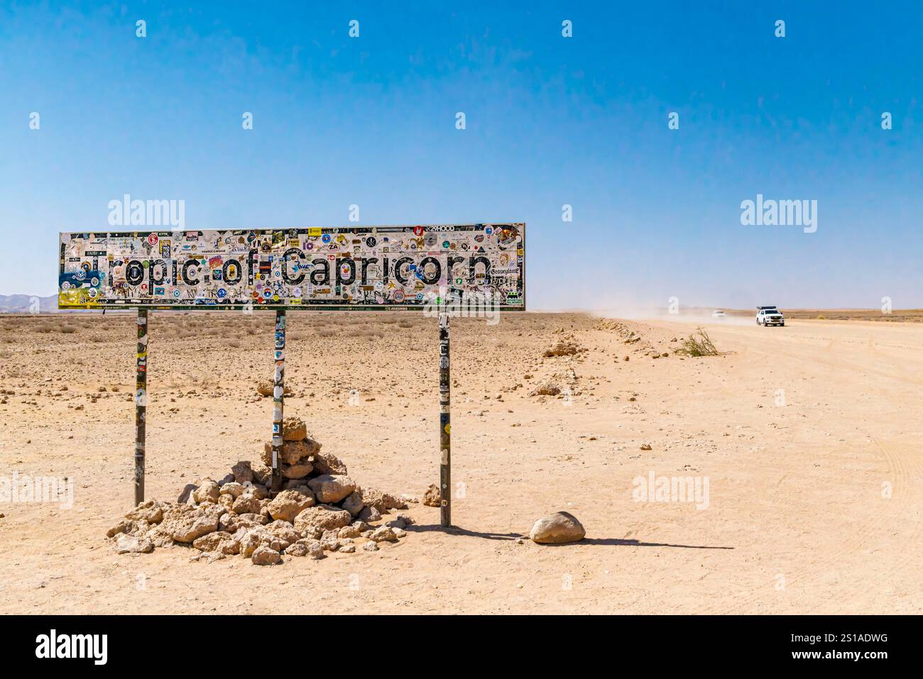 Namibie, district de Khomas, Solitaire, voitures sur la route de gravier traversant le tropique du Capricorne Banque D'Images