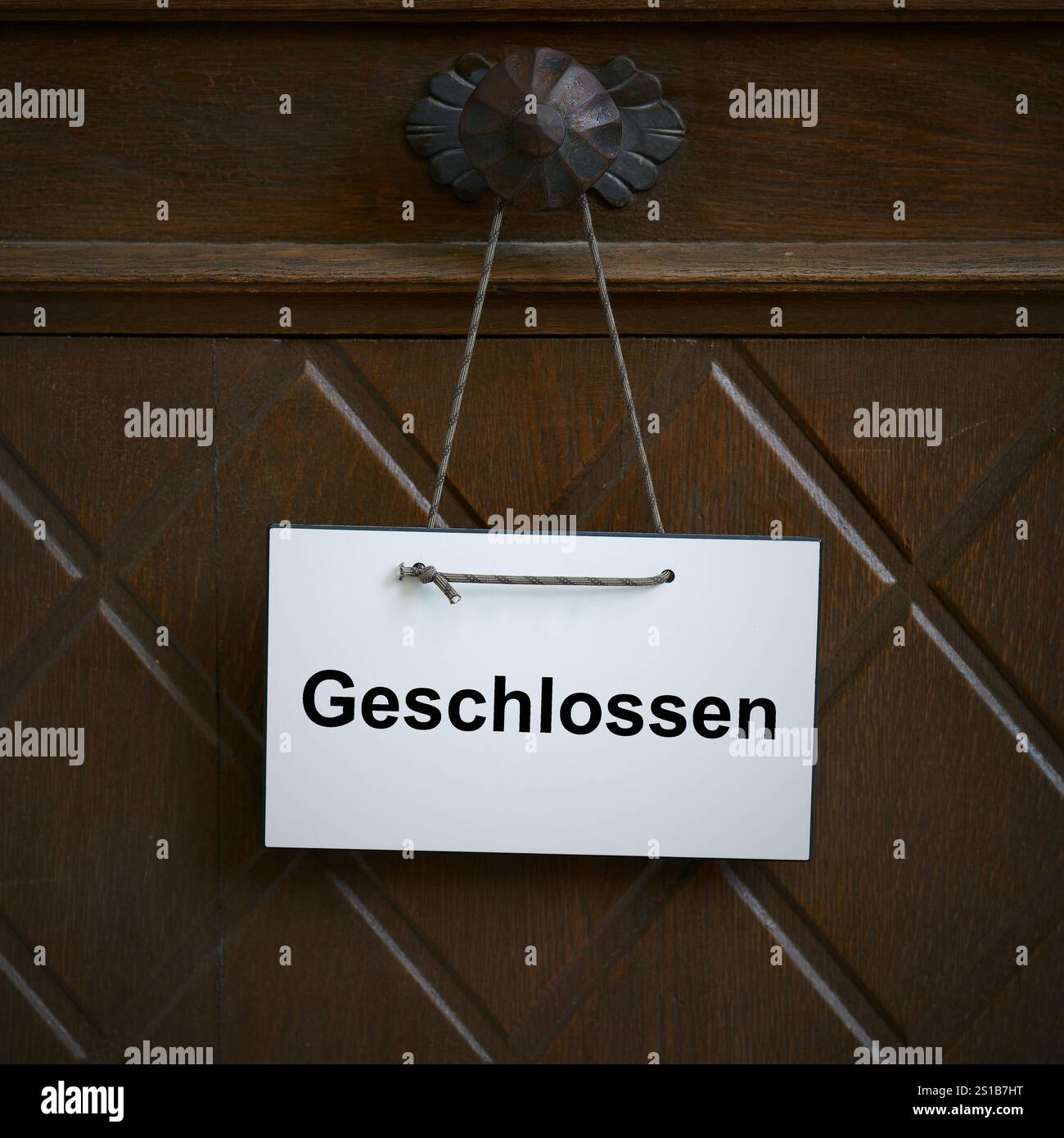 Signe sur la porte d'entrée d'un magasin avec le mot allemand geschlossen. Traduction : fermé Banque D'Images