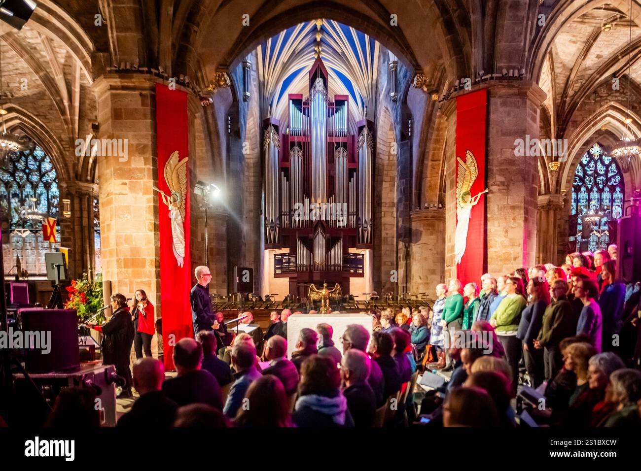 Édimbourg, Écosse. Mer. 1er janvier 2025. Représentation en direct de «Come Away In» à la cathédrale St Giles dans le cadre du premier événement Footin de la ville. Come Away In a été conçu et interprété par Karine Polwart (guitare / voix) en collaboration avec Stephen Deazley (chef de chœur), Corrina Hewat (harpe) et Lori Watson (violon / voix) avec une chorale communautaire à grande échelle spécialement recrutée pour l’événement. Banque D'Images