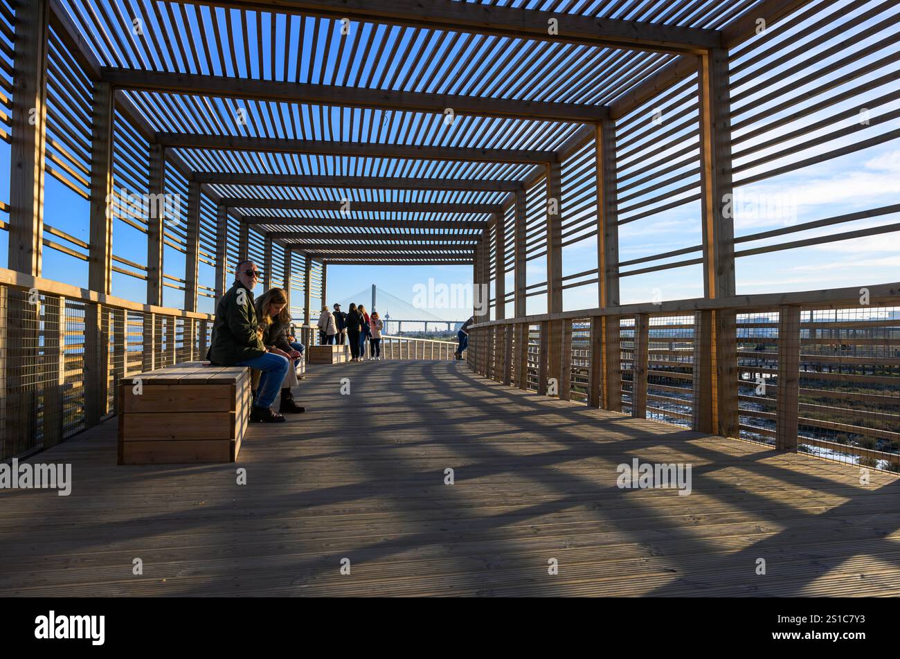 On voit des gens se reposer et marcher à l'un des postes d'observation de la faune appartenant au sentier Riberinho de Loures, situé sur les rives du fleuve Tejo à Lisbonne. Situé dans la municipalité de Loures, dans la région métropolitaine de Lisbonne, au Portugal, ce sentier pédestre ou promenade fait partie d'une initiative visant à revitaliser et à protéger l'environnement naturel et les rivières de la région. Ce projet s’inscrit dans le cadre d’une initiative visant à revitaliser et à protéger l’environnement naturel et les rivières de la région, et vise à promouvoir la mobilité durable, l’accessibilité et la jouissance des espaces publics à travers Banque D'Images