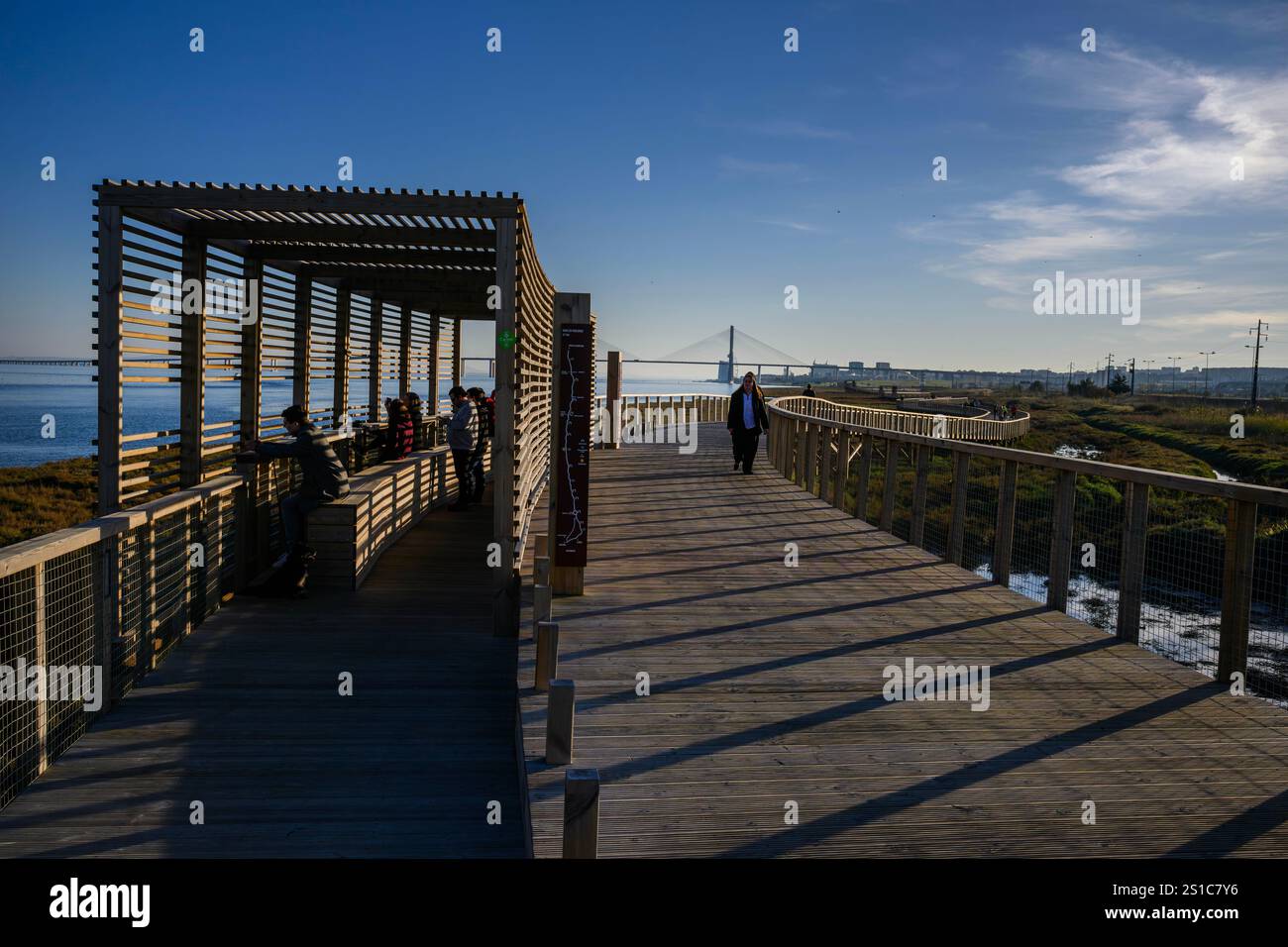 On voit des gens se reposer et marcher à l'un des postes d'observation de la faune appartenant au sentier Riberinho de Loures, situé sur les rives du fleuve Tejo à Lisbonne. Situé dans la municipalité de Loures, dans la région métropolitaine de Lisbonne, au Portugal, ce sentier pédestre ou promenade fait partie d'une initiative visant à revitaliser et à protéger l'environnement naturel et les rivières de la région. Ce projet s’inscrit dans le cadre d’une initiative visant à revitaliser et à protéger l’environnement naturel et les rivières de la région, et vise à promouvoir la mobilité durable, l’accessibilité et la jouissance des espaces publics à travers Banque D'Images