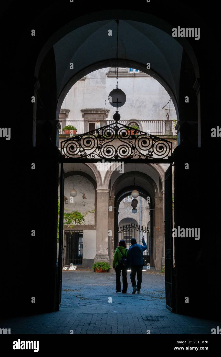 Vue vers la cour de l'église de Santa Maria della Pace avec un couple de touristes, via Tribunali, Naples Banque D'Images