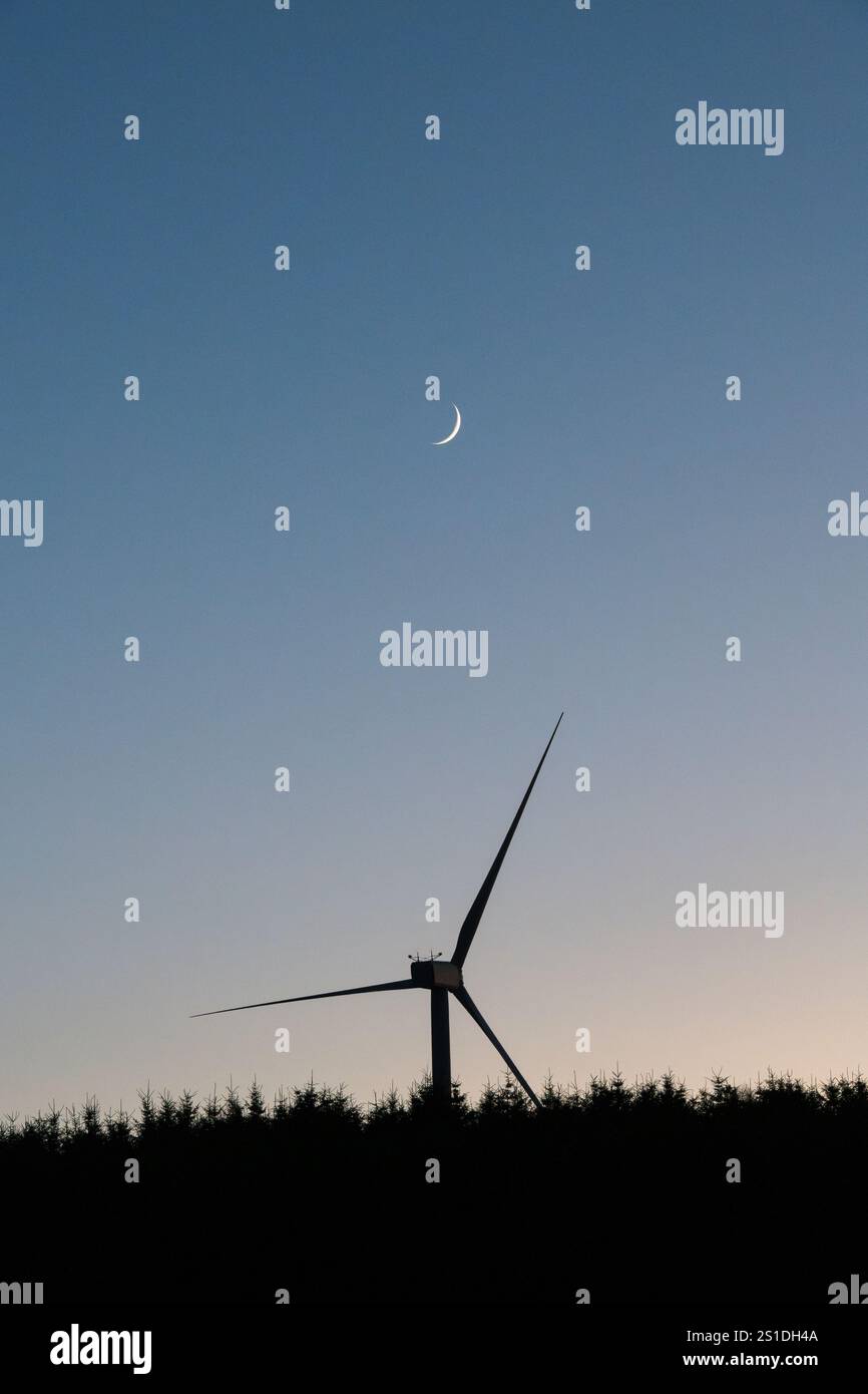 Éolienne et nouvelle lune, dans un ciel clair du soir (UK) Banque D'Images